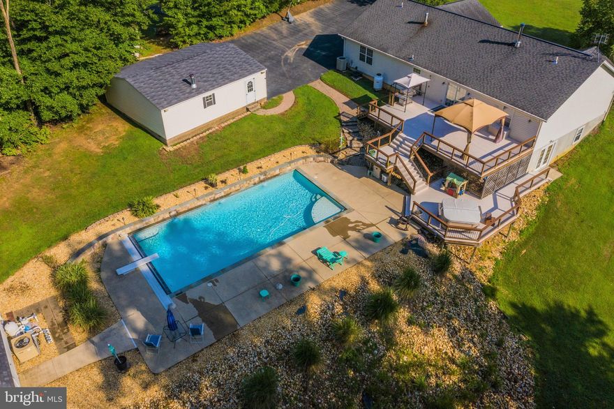 Your private oasis! Beautiful brick-front rambler situated on 4 acres with multi level deck with hot tub, overlooking heated in-ground pool with 3 waterfalls & electric safety cover. Over-sized 4 car detached garage with heat & cable TV plus attached 2 car garage. The interior has been remodeled with hardwood floors, brand new granite counter tops in the kitchen, stainless steel appliances, remodeled baths, wood burning stove in the great room, and cathedral ceilings. Fully finished basement with guest room or office, recreation room, kitchenette, full bathroom, and storage space! NO HOA!