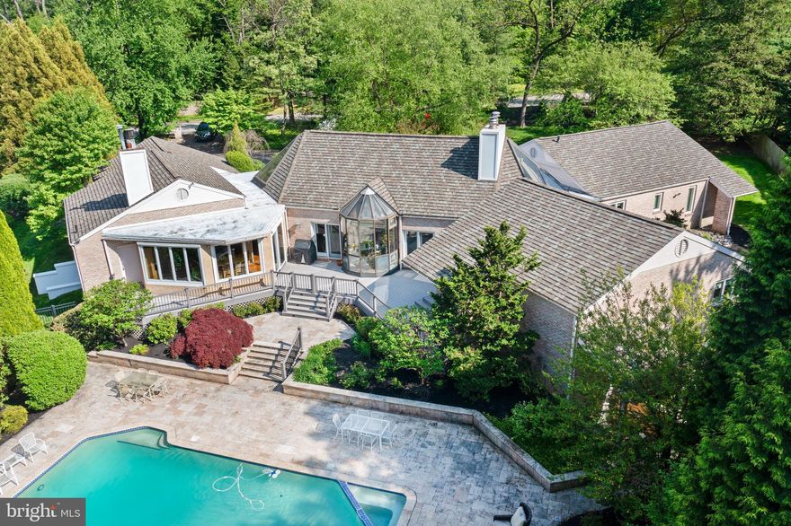 Presenting 1712 Washington Lane an exceptional property meticulously designed by nationally recognized architect Charles Broudy.  This all brick RANCH home is a stunning blend of modern design and classic charm.  The home is designed in a wing formation offering plenty of space and privacy for everyone.  Set on 1.35 manicured acres, this 5600 sq ft residence offers an upscale yet relaxed lifestyle.  As you approach the entrance by way of a circular driveway, double front doors open to reveal quarter oak flooring that extends throughout the main entertaining area.  The large triangle skylights and windows throughout fill the home with natural light.  The floor to ceiling windows offer panoramic views of the surrounding landscape, saltwater pool, koi pond with water fall and a gazebo to relax in.  Off of the Foyer is the Grand Dining Room and Living Room with 20 ft beamed ceilings.  This area is separated by a built in cabinet that is great for storing all your dishes and serving pieces.  Between these two rooms is a semi-circular working greenhouse for plants and flowers to be grown all year round.  The two rooms have french doors that lead out to the trex deck that surrounds the entire back of the home.  The spacious Living Room has doors that open to a unique sitting area with a wood burning fireplace and wet bar that can also accessed to the Living Room.  The large Dining Room has two built-in serving bars for buffet dinner parties.  The chef's Kitchen is perfect for entertaining and cooking enthusiasts.  Designed by Joanne Hudson this Downsview Kitchen is any cook's dream.  There are marble countertops, 3 Wolf ovens, 2 Miele dishwashers, sub-zero all refrigerator, sub-zero refrigerator and freezer drawers, separate ice maker and a sub-zero wine closet.  The stainless steel backsplash goes with the island that has stainless counter for cutting.  The Kitchen opens onto a cozy Family Room with a wood burning fireplace and built-ins.  Adjoining this room is the sun-filled Breakfast Area which allows the beauty of nature to greet you every morning.  This room allows you to access the deck.  Off of the Family Room is a Bedroom and Full Bath that can be used as an in-law suite or dressing area to the pool.  From the Kitchen you enter the Laundry Room with another sub-zero refrigerator and separate freezer.  There is a two car garage with storage, you can enter from this area and steps that lead to a partially finished Basement.  To the left of the entrance is a large Bedroom wing offering four Bedrooms with two jack and jill baths.  This wing is secluded and serene.  There is also an area with built-in desks and bookshelves.  The entire wing may be closed off from the rest of the home when not in use.  The Primary Suite offers a tranquil and luxurious atmosphere, a vaulted ceiling, door access to the deck and pool, two oversized walk-in closets and two separate bathrooms.  One of the baths has a large steam shower.  The second bathroom features a large triangular soaking tub, crystal sink and make-up vanity.  Both bathrooms have access to the built-in closets.  The partial Basement that is finished is perfect for relaxing after working out and has storage area and a wet bar and an outside entrance.  There is a stand up crawl space and under the primary Bedroom there is another unfinished basement.  This home with it's custom design and high quality construction, this is a true standout in the area.  Perfect for those who appreciate both luxury and comfort.  This Ranch home is sure to impress even the most discerning Buyer.