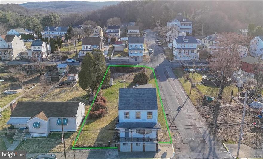 A corner property stretching street to street offers abundant outdoor space with a marvelous, sprawling home ready for you to make yours! A covered front porch opens to a large foyer, a window on the stair landing flooding the space with light from above, the coat closet is a bonus! A family room overlooks the porch with a large bow window and flows nicely into an equally spacious living room and on to the home's dining room with a second stair to the second floor! To the rear, the home's kitchen with access to an enclosed, covered side porch with outdoor storage closet and yard access. The second floor, accessed via two staircases, offers a total of five bedrooms, one a pass-through, each with a well-sized closet. The home's full bath completes this level. Above, the unheated attic is 250+sf of storage space or easily finished potential living space! The full basement houses the home's utilities as well as laundry facility with Bilco door access to the side yard. The home's fenced yard, to the rear and side of the property, stretches the full width of the block with gates on Washington and Nichols streets. Possibility is plentiful on this blank canvas with space for gardens, outdoor living room, and so much more! From the abundant room within, to the possibilities outside, plus its easy access to route 209 at the mid-point between Pottsville and Tamaqua, you don’t want to miss this opportunity!