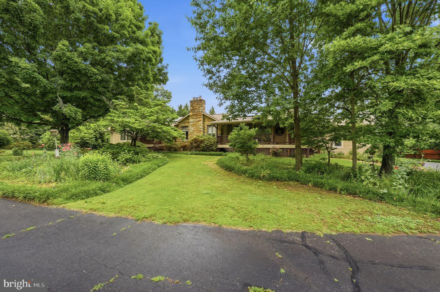 Discover the perfect blend of charm and potential in this expanded stone-front rambler. Set on over an acre of beautifully landscaped grounds with vibrant flower beds and gardens, this home welcomes you with a classic horseshoe driveway and a covered front porch.
Inside, the home has been expanded over the years and features a stunning primary suite with soaring ceilings, a comfortable family room with direct access to the back deck and a large eat in kitchen with island seating and a walk in pantry. The walk up lower level offers space for recreation, cozy movie nights by the fireplace or extra space for exercise or entertaining. While it has been updated throughout, it remains a canvas ready for your personal touches. Highlights include an oversized garage, a spacious rear deck for entertaining, and a serene, private setting in a sought-after neighborhood. Bring your vision and reimagine this spacious retreat!