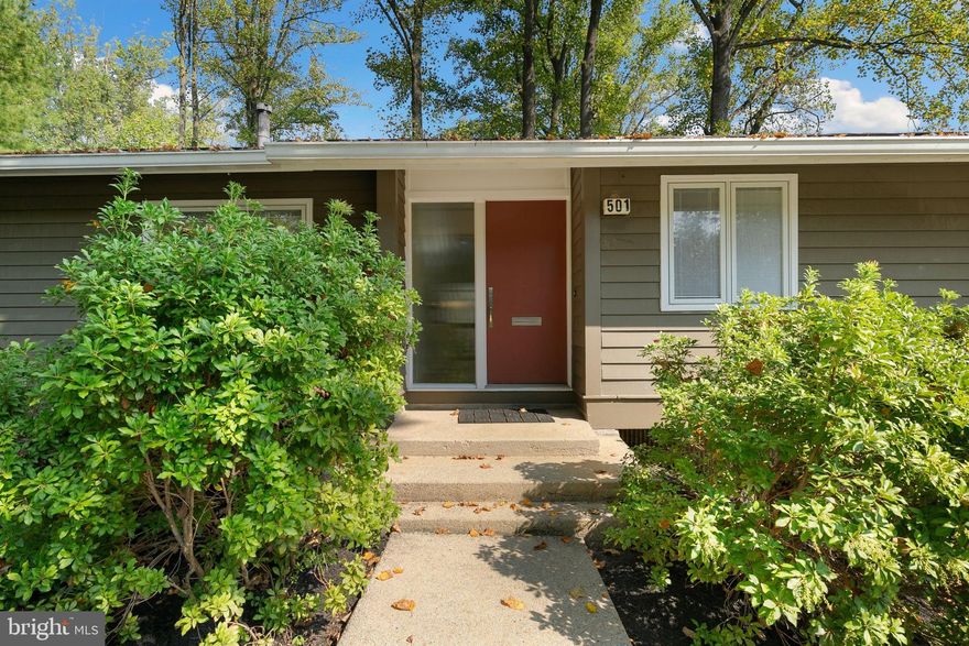 Outstanding opportunity to own this mid-century modern home set in the serene
community of New Mark Commons yet walkable to Rockville Town Center and Metro
with easy access to I-270 and Rockville Pike. A planned community of detached houses
and townhouses, the amenities of New Mark Commons include a beautiful lake,
swimming pool, tennis courts, basketball court, clubhouse, bike paths and a tot lot. 
This 1967 “Downhill” model was designed to blend in with the topography and
abundant landscape. It is set on a low maintenance corner lot, is a bi-level design
with a large, single-level entrance hall that opens to the living and dining areas,
the renovated kitchen and outside spaces include a side deck, back deck and lower
deck all of which offer private and serene seasonal views. The open living-dining
area has cathedral ceilings, prominent center wall gas fireplace and large expanses
of windows all of which have been updated with insulated glass. This main level
features wood floors throughout and also includes three bedrooms and two bathrooms,
including the primary suite with renovated bathroom. The lower level includes a large
family room, fourth bedroom, large utility/storage room, third full bathroom and entrance
into the extra-long garage with storage area. This impeccably maintained home with
just one owner won’t last long!  With multiple outdoor areas and walls of glass 
the house was designed to bring in light and connect with the outdoors. 
The home and neighborhood were designed by the award-winning firm of Keyes,
Lethbridge & Condon and developed by Edmund J. Bennett. The neighborhood was
listed in the National Register of Historic Places in 2017 and this specific home has
been highlighted in academic papers and local news. The house is conveniently
located just one block from the Ride On bus to the Rockville Metro and just .5 miles from
Rockville Town Center and Exit 5 off I-270 toward historic Rockville.
Truly a must see home.