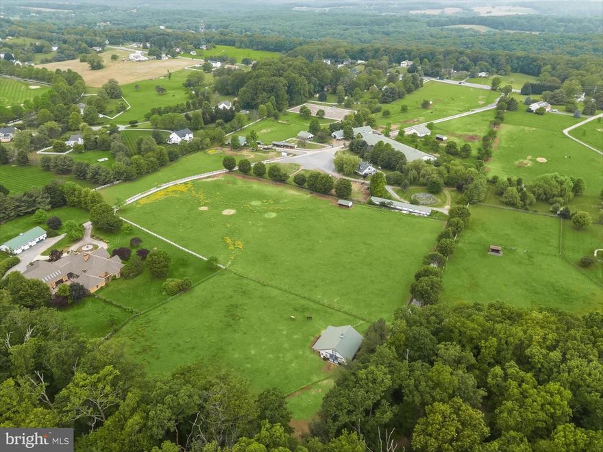 Welcome to 5641 Ridge Road, a turnkey, world-class equestrian facility where luxury, performance, and income potential converge seamlessly. Set behind a tree‑lined driveway on lush, white‑fenced pastures freshly limed and reseeded, this 28‑acre campus boasts forty meticulously maintained stalls housed in four distinct barns. The main barn features fifteen rubber‑matted stalls with automatic waterers, a heated wash stall with hot water, two spacious tack rooms, and a climate‑controlled office as well as dedicated feed room. A large stallion barn provides eight oversized stalls plus private feed, tack, and hay storage, while a leased four‑stall facility offers a center aisle four stall barn complete with its own feed and tack rooms for rental income. A ten‑stall shed‑row barn offers additional space or could function as guest stabling for shows, clinics, or ship-in clients and sits adjacent to the state‑of‑the‑art Aquatherapy Center. The Aquatherapy Center, one of only two in Maryland, features an underwater treadmill with dual‑filtration pumps, three heated stalls, a climate‑controlled wash stall and vet exam area with nonslip mats, two private offices, and a welcoming client reception area —ideal for high‑level sports‑medicine and rehabilitation or standalone veterinary practice. Imagine keeping your equine partner in peak physical condition year round or having the ease of safely rehabilitating injuries onsite.

Year‑round training and competition are effortless here. A heated indoor arena features new premium footing, energy‑efficient LED lighting, and propane‑fired heat with thermostat control; tiered spectator stands overlook the arena, and an adjoining full bath, café‑style kitchen (convertible to an apartment), and private office making it perfect for clinics or shows. Outside, a 250′×150′ all‑weather arena with new LED light fixtures, a dedicated water line, and an “Enchanted Garden” seating nook invites relaxed viewing of dressage tests or jumping courses. The outdoor arena is flanked by a custom waterfall feature and custom landscaped pond creating the most scenic backdrops for photographing your horses as they work. Cross‑country jumps pepper the surrounding fields, and a pavilion with electric hookup offers sheltered storage or a place to host clients.

The residential offerings are equally impressive. The main house features over 9,000 square feet under roof with five bedrooms on the main floor —including a sumptuous owner’s suite with a massive walk‑in closet—an Italian‑marble living room, a newly renovated chef’s kitchen with granite countertops and stainless‑steel appliances, hardwood floors throughout, a private home office with built‑ins, and a heated indoor pool with towering rockwall and waterfall feature with its own attached half‑bath. A tennis court and expansive back patio complete the picture for gracious entertaining. 

Additional amenities include abundant storage sheds for shavings, equipment, and round bales; a charming petting‑zoo enclosure for emus, mini‑donkeys, and chickens; and a robust lesson program, show series, and clinic calendar available for transfer. Select on‑site equipment may be purchased separately and a price sheet is available upon request. 5641 Ridge Road is shown by private appointment only to qualified buyers—no drive‑bys, please. Discover a turnkey equestrian destination where every detail has been designed to elevate your dreams; schedule your private tour today.  Please see extensive uploaded information including a list of improvements and upgrades made in the last few years!