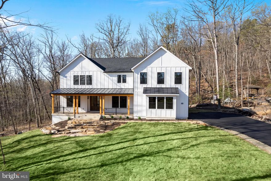 Welcome to the epitome of luxury living and exclusivity, located within the Bull Run Mountain Estates (conservatory), in the rapidly appreciating area of Haymarket, VA (20169). Enjoy your privacy, surrounded by nature on your nearly 1acre (.096) homesite, situated in a quiet cul-de-sac on a premium level lot, with NO HOA! From the moment you enter your 8’ high double front doors, you’re drawn past the fully outfitted office, and separate formal dining room, to the warm and inviting expansive family room – complete with a stone fireplace that rises to the soaring ceiling. Maybe you would prefer to pass through the custom-made glass sliders, onto the outside rear deck that overlooks your very own mountain creek, located on your property. Directly adjacent to the family room is the luxuriously equipped gourmet kitchen, with an oversized island for meals, drinks, and entertaining. Just down the hall is your well-appointed main level Primary Suite #1, complete with ensuite bathroom, and large walk-in closet, perfect for an in-law retreat or quest quarters. Just a few steps further will whisk you past the main level laundry/mud room, complete with built-ins and pet washing station. For your convenience, the connecting oversized 2 car attached garage is outfitted with an electric vehicle charging station. The remaining family members/quests can retire to the upper level – including Primary Suite #2 (large bedroom with an exquisite ensuite bathroom, double walk-in closets), and sliding glass doors to the covered balcony, while overlooking & listening to your very own mountain creek. Meanwhile, the upper level additional 2 bedrooms each are appointed with their very own ensuite bathroom and walk-in closets. An additional upper-level laundry facility is included for your convenience, along with an adjacent separate area, ideal for lounging and/or your personal library. Then, it’s onto the fully finished lower level, including an additional fireplace, an expansive Great Room with a fully equipped bar, a separate theater room, a full bathroom, and a Bonus Room that could be used for a home gym (not included), wine cellar, or additional bedroom. This eco-friendly luxury home is built by MetroGreen – a local reputable luxury builder. It’s equipped with high-quality finishes throughout all levels; custom-made fiberglass “Marvin” windows and sliders; exterior hardie-plank siding; professionally landscaped yard. Includes 2-10 Home Buyer Warranty! Whether you’re interested in hiking or biking the wooded trails behind this exquisite home or care to take a short drive to enjoy the amenities of Bull Run Golf Club, Evergreen Country Club, Trent Jones Golf, or join one of the local fitness centers, your health & fitness goals are covered.