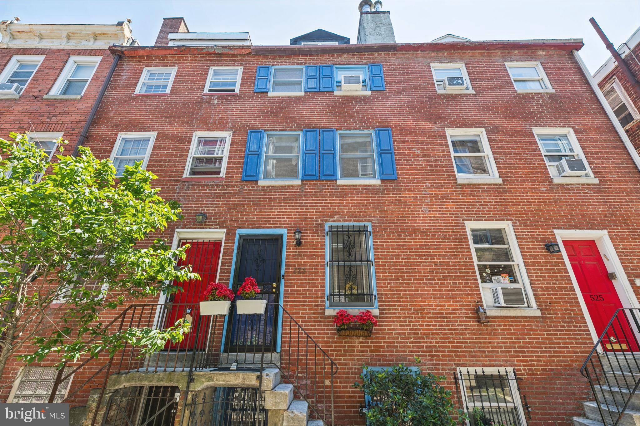 Planned and built in the Georgian style while Thomas Jefferson was still President, this charming, historically certified property is located in the Society Hill Historic Preservation District. Expanded trinity with wood flooring throughout. Full of character on a centrally located, desirable block. The street-entry level features a lovely living room with an exposed brick fireplace, a half bath, a rear two-story window wall currently used as a natural-light indoor garden area with a cozy conversation nook, a coat closet, and access to a brick patio with new fencing. This private outdoor space includes a five-foot-deep Canadian cedar hot tub under a gazebo with side privacy panels, plus a barbecue or garden area. Stairs lead down to a lower-level kitchen with separate street access and a full dining area with a brick fireplace and wood flooring. The second floor has one bedroom with a brick fireplace and wood flooring, as well as a large primary bathroom with a soaking tub, double vanity with granite top and vessel sinks, and a glass block wall that allows for abundant natural light. The third floor features another bedroom with wood flooring and access to a privacy-walled roof terrace—ideal for private sunbathing or moonlit cocktails. The fourth floor is a dormered third bedroom.
One level below the kitchen is an unfinished basement, which includes a massive arched walk-in fireplace—possibly originally used for cooking. New water heater (2020) and roof (2018).