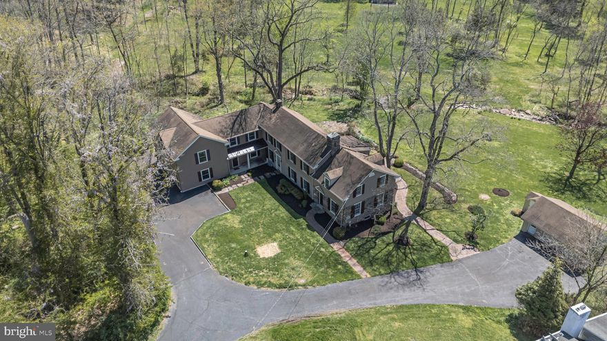 Set on over two private acres assigned to the highly sought-after Council Rock North High School, this charming farmhouse offers a rare blend of historic character and serene natural surroundings, complete with a stream, koi pond, and beautifully maintained grounds. Tucked well back from the road, the home provides exceptional privacy and a peaceful, retreat-like setting. Inside, timeless details shine throughout the original portion of the home, including exposed stone walls, deep windowsills, original built-ins, and solid wood doors. The main living level is both functional and inviting, featuring a spacious kitchen with island overlooking the backyard, an adjacent eat-in area, full bath, and convenient laundry. A generously sized dining room with charming built-ins flows seamlessly into the sunroom, where exposed stone walls and sweeping views of the property create a truly special space. The large living room showcases exposed beams, deep windowsills, and a beautifully updated pellet stove. A back staircase leads to a stunning art studio with soaring ceilings and plumbing in place, offering incredible potential to create a luxurious primary suite. The original staircase leads to three bedrooms and two full baths, along with additional flexible space that could easily be expanded into a larger primary suite or additional bedrooms. Additional highlights include an attached two-car garage, a detached two-car garage ideal for storage or hobbies, and a whole-house generator for added peace of mind. Lovingly and meticulously maintained, this is a rare opportunity to own a private Bucks County retreat with character, flexibility, and endless potential. Schedule your private showing today!