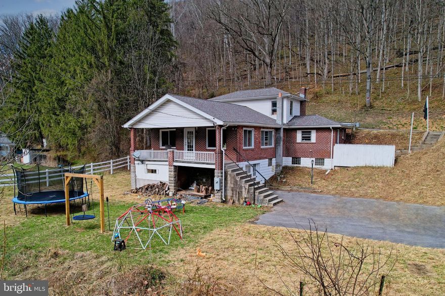 This charming 3-bedroom, 2 full bath home offers more space than meets the eye with 1,848 above-grade finished square feet and a layout designed for comfortable everyday living. Located outside of city limits on a .28-acre lot, you will enjoy the perfect balance of convenience and peaceful surroundings, with easy access to I-68 for travel east or west.  Inside, you will find a spacious living room and large dining room, giving you plenty of room to gather, entertain, and make yourself at home. The updated flooring completed in 2020 adds a fresh touch, while the stove and refrigerator convey for added value. Major improvements include a roof and gutters replaced in 2021 and a coal furnace installed in 2020. (Note: Per the previous information given by the prior owner of the property and noted in previous listing of the home.)  
The unfinished basement offers an abundance of storage space, a full bath, and great potential for a workshop, hobby area, or future customization. With oil, wood, or coal heat options, this home gives you flexibility and functionality to fit your needs. Take in the beautiful mountain views and enjoy the benefits of country-style living while still being close to major routes and conveniences. If you are looking for space, value, and potential, this home is one you will want to see!   Call today and schedule a tour!