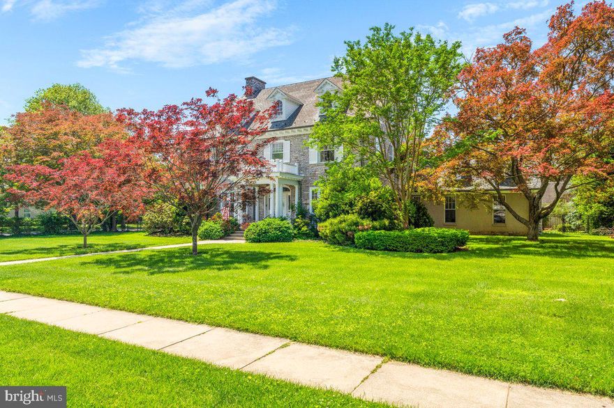 Nestled on one of the city’s most picturesque, tree-lined streets, this 1925 Georgian Colonial blends classic architectural elegance with upscale modern updates, offering nearly 6,000 square feet of refined living space in a walkable, sought-after location. Just one block from Baker Park and Hood College, and minutes to Carroll Creek, the MARC train, and vibrant downtown Frederick, this home places you in the heart of it all, where sidewalks connect neighbors and every corner invites exploration. Set on an expansive and rare 0.65-acre lot, the fenced backyard offers both function and beauty—ideal for entertaining, gardening, play, or even your dream pool. Multiple covered porches extend the living space outdoors, and you can enjoy Frederick’s Fourth of July fireworks from your yard. A detached 3-car garage with updated frontage (2024) offers ample storage and convenience. Inside, rich hardwood floors, original millwork, and a grand staircase speak to the home’s heritage, while thoughtful renovations—like the chef’s kitchen with Thermador and Bosch appliances, quartz countertops, and custom cabinetry—bring elevated comfort to everyday life. The stunning great room features vaulted ceilings, a floor-to-ceiling brick fireplace, and a custom mural of Frederick’s clustered spires by William Cochran. Upstairs, the luxurious primary suite includes walk-in closets and a spa-inspired bath. The third-floor in-law/au pair suite offers two bedrooms, a full kitchen, and separate living and dining—perfect for multigenerational living or long-term guests. Updates include a new roof (2025), refreshed paint throughout (2021–2025), landscape enhancements, and system upgrades for peace of mind. Currently priced below assessed value, this home presents not only a rare opportunity but exceptional value based on its square footage, lot size, and oversized garage. A home that offers not just beautiful spaces, but an unbeatable lifestyle in one of Frederick’s most treasured neighborhoods.