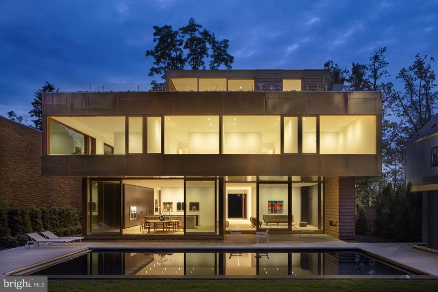 3131 CBR is the latest modern masterpiece by internationally acclaimed architect David Jameson - known best for creating habitable art. Timeless and elegant, the striking exterior is wrapped in custom Bronze panels, handmade English clay brick tiles, and custom Sapele windows and doors. The serene rear garden boasts thoughtfully sculpted landscaping, stone slab terraces, and a saltwater pool with cabana and full bathroom - all overlooking the natural beauty of Battery Kemble Park. A dramatic 10' x 8' pivoting glass door provides access to four levels and 12,200 square feet of luxurious open concept living space. The light-filled main level features a two-story living room with fireplace, formal dining room, butler pantry, and chef's kitchen open to both the breakfast and family rooms. Floor-to-ceiling glass windows including an array of 11'x7' sliding doors seamlessly blur the indoor-outdoor living experience and frame views to the pool, rear garden, and park beyond. Six bedrooms and a total of six full + two half bathrooms throughout the home provide extraordinary comfort and privacy for family and guests. The Primary suite with large sitting area includes a dressing room encased with custom Macassar ebony cabinets in addition to several other closets; marble slab bathroom with dual vanities, and custom separate tub and shower; second full bath with marble countertops, shower, and custom cabinets. The home's top level includes a lounge with kitchenette, office, and sliding glass doors opening to a wrap-around terrace and green roof offering panoramic vistas from DC to Virginia, Maryland, and the Potomac river basin. A car collector's dream - the lower level provides garage parking for 6+ cars and ample storage. This impressive space is climate controlled and doubles as an event space with twelve-foot ceilings and programmable custom lighting.