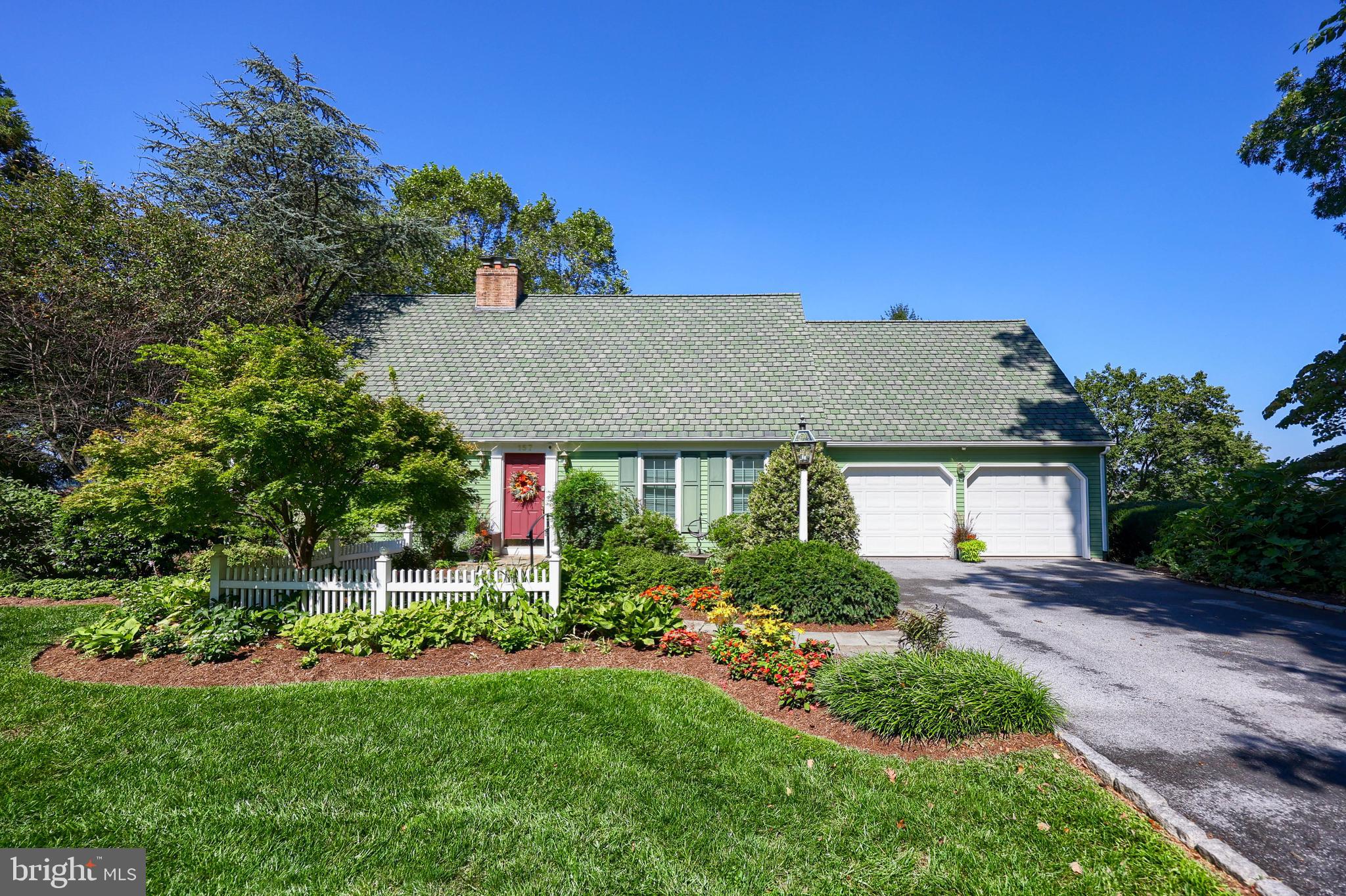 Welcome to 157 Maple Drive, New Holland, a beautifully maintained Cape Cod home in a quiet and welcoming neighborhood. Set on nearly ½-acre of lush, landscaped grounds with mature trees ensuring year-round privacy, this gem has been lovingly cared for by its original owners since 1969. Thoughtful renovations bring fresh life to the home, including a stunning kitchen remodel, a spa-like master bathroom, and a spacious walk-in closet. Beautiful hardwood floors, elegant wainscoting, and crown molding flow throughout, complemented by lots of storage space throughout the home and a 2-car garage for added convenience.
Step downstairs to the basement where a barnwood-accented family room with stunning stonework adds cozy rustic charm and another finished room that can be used as a study, guest room, or nanny suite. Two other spacious partially finished basement rooms await your vision for a dream project—a kitchen staging area for your next outdoor gathering, a workshop, game room, gym, or home theater. From here, walk out to a patio that opens into the backyard, perfect for morning coffee or evening gatherings. Upstairs, the large deck is ideal for outdoor dining, capturing breathtaking sunsets over New Holland, alongside a dramatic illuminated urn water feature that sets the stage for memorable evenings.
The property is surrounded by immaculate landscaping and mature trees, offering both beauty and privacy. Perfectly situated in Eastern Lancaster County, you’re close to farms, orchards, and garden nurseries, with easy access to major cities and attractions. Don’t miss this opportunity to own a well-crafted, charming home in New Holland!