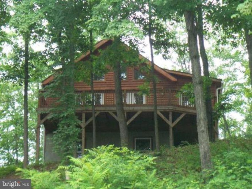 Whether you are looking for outdoor activities at Coolfont Resort, the State Park in downtown Berkeley Springs and Cacapon Resort State Park or visiting the  wonderful restaurants, spas, antique and quaint shops in downtown Berkeley Springs, this Chalet is just minutes away from it all!   Wheelchair accessible Chalet features an entrance room with spacious closet to keep coats and shoes from cluttering the home.  Open Great Room has living room with a wall of windows, dining area and kitchen, all with wood floors.  Kitchen has corian counter tops with island and pantry.   Owners main level bedroom has new carpet and features a large walk in closet and spacious bathroom with jacuzzi tub plus a shower.  Spacious deck off the Great Room for outdoor entertaining.  2BR & 1 BA on upper level.  Full walkout level basement has a large Family Room with a pool table that conveys with the home plus a 4th bedoom and full bath, radiant heated floors and plenty of window for natural light.   Beautiful stone patio with steps to a gazebo are accessible from the family room.  Above ground pool with deck also conveys with the sale.