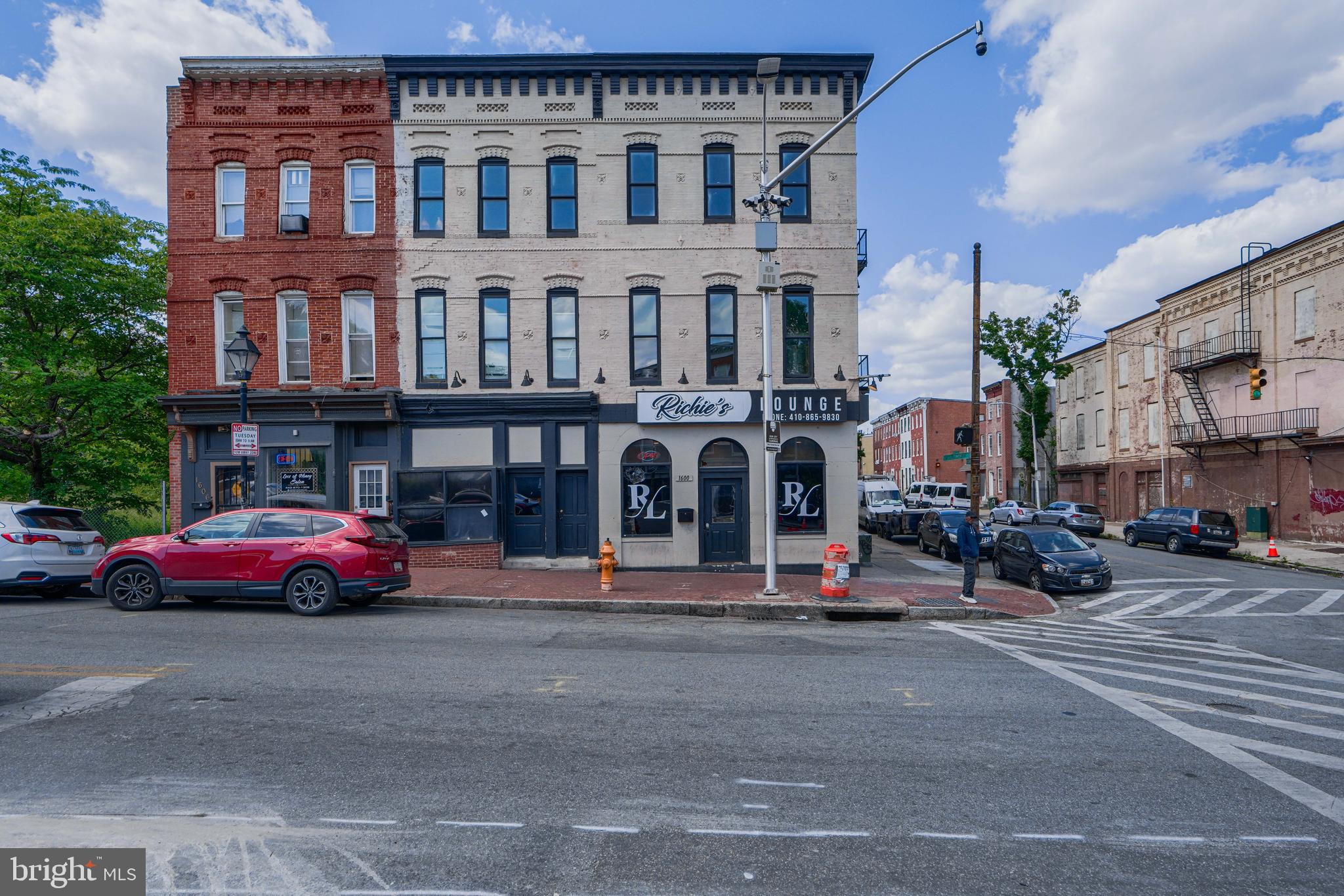 Presenting a rare Baltimore investment property that combines a popular tavern and nine residential units under one roof. Investors and property buyers will appreciate the multiple income streams and unique flexibility of this mixed-use real estate gem. Currently operating as Richie’s Lounge, the first-floor tavern holds a 7-day beer, wine & liquor license (valid through April 30, 2026) and is approved for live entertainment and dancing – offering immediate revenue from nightlife operations. Above the bar, nine (9) apartment units provide steady rental income, making this a truly income-producing property in Baltimore with exceptional value-add potential.
The tavern space is full of character and functionality, featuring original details like three fireplaces, a dedicated DJ booth, an upstairs kitchen with half-bath, and two multi-stall restrooms for patrons. All existing bar fixtures and equipment convey in the sale, creating a turnkey venue ready for operation from day one. The residential units upstairs consist of three finished studio apartments and four finished one-bedroom apartments that are rent-ready, plus two additional one-bedroom units primed for renovation (with city-approved construction plans included). This setup allows an investor to start earning rental income immediately while adding value by completing the remaining units.
Whether you’re looking to expand your portfolio with a high-yield mixed-use asset or launch your own hospitality venture with on-site rental income, 1600 W Baltimore Street offers an unparalleled opportunity. It’s situated in Baltimore City along a prominent corridor, ensuring visibility and accessibility. Don’t miss the chance to acquire this unique bar-and-apartments property – a versatile, income-producing Baltimore investment with both immediate cash flow and long-term growth potential. Property is owner occupied, and will be delivered vacant at time of settlement.
Property Highlights:
Unique Mixed-Use Configuration: Three-story brick building ( 7,071 sq ft) combining a commercial tavern/lounge on the ground floor with nine residential apartment units above.
Turnkey Tavern (Richie’s Lounge): First-floor bar comes fully equipped and furnished, featuring 3 fireplaces, a DJ booth, an upstairs kitchen with half bath, and two multi-stall restrooms. All bar equipment and fixtures convey with sale.
Active Liquor License & Entertainment: Includes a valuable 7-day Beer, Wine & Liquor license (valid through 4/30/2026) with approvals for live entertainment and dancing, offering immediate operational capability and nightlife revenue.
Nine Apartment Units: Upper levels contain 3 finished studio apartments and 4 finished one-bedroom apartments, all ready to lease for instant rental income. Two additional one-bedroom units are framed and ready for renovation, allowing further income growth (permits and drawings already approved).
Value-Add Upside: City-approved plans are in place for completing the unfinished units, streamlining the process to increase property value and cash flow. Ideal for investors seeking both stable income and future appreciation.
Strong Income Potential: Multiple revenue streams from tavern sales and apartment rentals make this a high-potential, income-producing property – perfect for diversifying an investment portfolio or for an owner-operator looking to offset business expenses with rental income.
Prime Baltimore Location: Situated at 1600 W Baltimore Street in Baltimore City, the property enjoys a high-visibility corner location in a historic urban corridor. It’s convenient to downtown amenities, public transit, and major thoroughfares, attracting both local patrons and tenants alike.