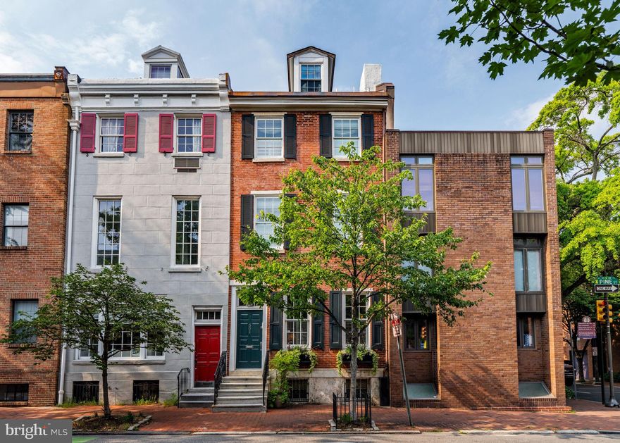 Impeccably designed four-story townhome with a finished lower level and spectacular backyard oasis along storied Pine Street. This gorgeous home boasts excellent entertaining space, hardwood floors, high ceilings, custom built-ins, incredible natural light, and multiple outdoor spaces including a one-of-a-kind rear patio with exquisite hardscaping. Enter the home through a vestibule with marble tile floor and glass-paned door into a light-filled living room boasting two large windows overlooking Pine Street, a gas fireplace with marble surround, large coat closet, and access to the grand central staircase with beautiful wood work and trim. Past the living room is the beautifully appointed chef's kitchen with flat wood cabinetry, granite countertops and backsplash, double bowl stainless steel sink with garbage disposal, center island with Dacor wine refrigerator and breakfast bar, and high-end stainless steel appliances including a Sub Zero refrigerator, Viking oven with six burner gas range and Faber hood, Wolf built-in microwave, and Miele dishwasher. Open to the kitchen is the formal dining space with room to easily fit an eight-person table and a spectacular view of the rear patio from a wall of floor-to-ceiling windows. From the lush climbing vines to the high stone walls, this gorgeous patio is the ideal private urban oasis. Features include bluestone pavers, built-in stone garden beds, water hookup, space for grilling and outdoor dining, and steps leading to the lower level. Unique to this type of home is the expansive finished lower level with standard ceiling height and incredible entertaining and storage space. There is a built-in entertainment center with display shelving and storage, built-in speakers, stone tiled powder room, open skylight looking upwards towards the center of the main staircase, secondary storage room behind a set of French doors, and a third storage room with easy access to the home's mechanicals. The second floor houses a cozy den/study with built-in entertainment center and bookcase and the primary suite. Off of the den is a large balcony nestled in the trees, that's perfect for enjoying a morning cup of coffee. The spacious primary suite features two large windows overlooking Pine Street, excellent closet space, built-in speakers, and an ensuite bathroom with designer marble tilework, double wooden vanity with marble top, and a glass-enclosed shower. The third floor has two large bedrooms both with ensuite bathrooms and excellent closet space. The rear bedroom is currently being used as an office and enjoys access to a French balcony. The front-facing bedroom has a laundry closet with stacked washer/dryer and a beautifully appointed bathroom with corner soaking tub. Walking up to the fourth floor, you will immediately notice the three-pane skylight that floods the staircase and room with natural light. There is a built-in desk nook, perfect for a home office, and a front-facing bedroom with marble appointed ensuite bathroom and wall closet. Additional home highlights include recessed lighting, 2GIG smart security system, Diamond wood floor inlay from the living to dining room, California closets all with custom-built-ins, and exquisite moldings and trim throughout. Located in the desirable Society Hill neighborhood walking distance to Washington Square and South Street. In close proximity to the Delaware River waterfront, incredible restaurants, parks, cafes, retail, theaters, and cultural institutions. There are multiple monthly parking options nearby, as well as ample on-street parking.
