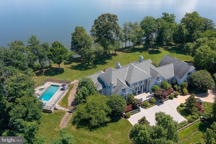 A RARE OPPORTUNITY -- PREMIER WATERFRONT ESTATE IN STONE MANOR! 
This private, luxurious estate offers over 570 feet of direct Potomac River frontage including a sandy beach, set on over 5 acres within the prestigious, gated enclave of Stone Manor on the Potomac. Designed for those seeking space, serenity, and spectacular views, this grand waterfront retreat lies just 30 minutes to Washington DC, Old Town Alexandria, and Tysons Corner—and offers the ultimate in privacy, luxury, and natural beauty.

Custom-built with no expense spared, the 15,000+ sq ft residence is strategically sited to maximize panoramic river views and take full advantage of the spectacular sunrises visible from nearly every room. Inside, elegant living spaces unfold. A soaring two-story great room with a full wall of glass anchors the home and offers unobstructed river vistas. The expansive chef’s kitchen opens to the casual and formal dining spaces, and the family room. The richly paneled  2-story library with a fireplace and the office with riverfront views provide a quiet place to work or unwind. The luxurious primary suite features a wall of windows overlooking the water, an expansive spa-like bath with jetted tub and steam shower, dual walk-in closets, and private access to both the terrace and pool. Brazilian cherry floors extend through much of the home, complemented by Venetian plaster walls in the dining room and custom murals/paint in the great room and foyer. 

Upstairs, a series of generously sized bedrooms and elegantly appointed baths provide privacy and comfort for family or guests. A separate guest suite—complete with its own kitchen and private entrance—adds flexibility.

The walkout lower level was designed for entertaining, featuring a expansive recreation room with a fireplace and a custom bar, a home theater, a fitness studio, and a full bath with an indoor spa and sauna.

Additional highlights include:
– Six spacious bedrooms and 7.5 baths
– In-law/guest suite includes a living room, kitchen/dining room, bedroom, and 2 full baths
– Four-car garage
– Heated pool and hot tub overlooking the river
– Extensive landscaping and uninterrupted river frontage framed by mature trees.

Boating enthusiasts will appreciate the assigned deep water slip at the community marina, adjacent to the property. With over 570 feet of waterfront—and one of the few homes in Stone Manor on the Potomac boasting a private sandy beach—this estate offers rare opportunity to experience luxury waterfront living with total privacy. Imagine starting the day with coffee and a spectacular sunrise, hosting gatherings in the grand indoor and outdoor spaces, unwinding by the pool, or watching moonlight dance across the river. Perched at the water’s edge, this property invites you to embrace the serene, unhurried rhythm of life on the Potomac.

A legacy property. A lifestyle unmatched.