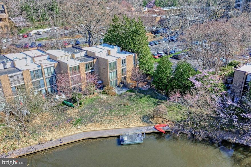 Welcome to 11459 Washington Plaza W — an end-unit townhome that perfectly blends privacy with accessibility to all that Reston has to offer. Nestled along a tranquil canal of beautiful Lake Anne, this stunning property puts you just steps away from vibrant restaurants, charming shops, unique experiences, and the lively Saturday farmers market. Plus, the bustling Reston Town Center is just 1.5 miles from your front door, offering upscale dining, shopping, and entertainment options.

The beauty of this home begins before you even step inside, with a spacious stone patio that is framed by a uniquely designed privacy fence. This mid-century modern townhome boasts 4 bedrooms, 2.5 bathrooms, and an abundance of natural light streaming through floor-to-ceiling windows and skylights, offering beautiful views from every room. Gorgeous original hardwood floors flow throughout, showcasing the home’s timeless appeal.

The main level features a well-appointed kitchen with stainless steel appliances, generous counter space, and two breakfast bars — perfect for morning coffee or casual meals. Enjoy quick access to both the front and back porches, as well as the inviting dining area framed by expansive windows. An open staircase leads to the airy and spacious living room, where lake and garden views create a serene backdrop.

Venture down to the fully finished lower level, where you’ll find a versatile recreation room, a conveniently located powder room, and a recently updated washer and dryer. Step outside to the large deck with built-in seating and garden beds — the perfect spot to unwind while enjoying peaceful canal views, lush trees, and the expansive grassy common area.

Upstairs, the upper levels house four bright and spacious bedrooms, two full bathrooms, and a linen closet. This centrally located yet exceptionally private home also provides access to Reston’s top-tier amenities, including swimming pools, sports courts, dog parks, and walking trails. Parking is conveniently located just steps away, with guest parking close by.

Experience the best of Reston living in this rare waterfront opportunity!