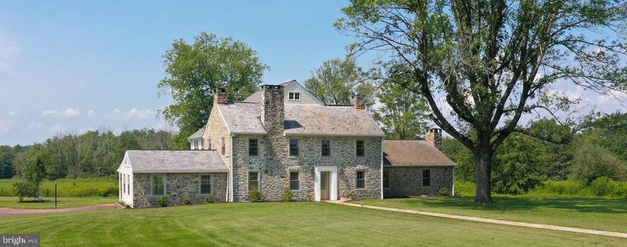 Resting on 64 acres of preserved land, Stone Walk Farm is a countryside haven in picturesque Bucks County. Past a spring fed pond & Pennsylvania bank barn, the circular driveway leads to a stately stone farmhouse dating to the mid 1700s. A sun filled interior boasts beamed ceilings, glistening wide width pine floors & 5 fireplaces on 3 levels. Beautifully maintained & updated, voluminous rooms retain deep windowsills & exposed stone walls. Showcasing views of the inground swimming pool & vast property, the keeping room has 2 walls of floor-to-ceiling windows. A modern kitchen with breakfast area leads to a deck with sweeping vistas of fields and woods beyond. 3 bedrooms on the 2nd level include a primary suite with private balcony & another with a stone fireplace. Skylights & dormers bring charm & light to the uppermost level. A main floor laundry room, garage & storage space in the well-preserved barn & 4 zone heating are convenient amenities.