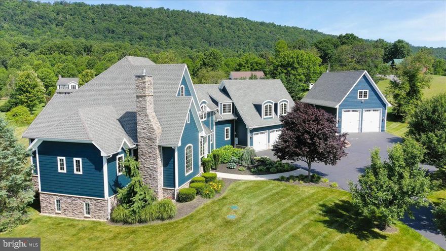 Nestled on just over an acre, this custom-built estate offers stunning mountain views and is an architectural masterpiece. As you drive up the tree-lined driveway, you are greeted by the expansive grandeur of the home.
The exterior boasts Hardy plank concrete siding and stone along with an oversized three-car deep bay garage, with a utility sink and an EV car charger. A front paver firepit adds another space for entertainment.  The 26 x 45 detached garage features oversized 12 x 12 automatic garage doors, w/ reinforced 6" thick concrete floor. An unfinished structural space above garage with complete utility access for future possibilities.
A magnificent two-story foyer sets the tone for the elegance inside. The first floor features grand 8-foot solid walnut doors, elegant bullnose cornered drywall. The first and second floors are adorned with 5" wide hickory hardwood, with ceramic tile in the bathrooms, creating a cohesive and luxurious feel.
The great room features built-ins, gas fireplace and access to the rear deck.  Additional amenities include a complete whole-house intercom system, whole house audio, security system, central vacuum, and main level laundry room. The chef's kitchen features granite countertops, under-cabinet accent lighting, and 2 dishwashers, two ovens, warming tray, and wine fridge.  The crowning jewel is a Bertazzoni 48" double gas oven with six burners and an electric griddle, complemented by a pot filler. The kitchen includes a breakfast bar and a large breakfast nook with breathtaking mountain views, perfect for enjoying a meal or watching the sunset. The gathering and entertaining possibilities are endless with a separate formal dining area.
Master bedroom on the first floor is a sanctuary of luxury, offering a seating area, private bath with a 5 x 5 tile shower, air soaking tub, double vanity sinks, two walk-in closets and private access to deck.
Ascending the front or rear staircases, the second floor boasts a charming balcony seating area, two bedrooms sharing a Jack and Jill bathroom, a convenient laundry chute, and walk-in attic access with climate control. The luxurious in-law suite offers an enclave of privacy and comfort, featuring a cozy bedroom, a serene living room, and a full bath, perfect for extended family or guests.
Walk-out basement adds significant value and versatility with two bedrooms (ask listing agent for details),  gym room, and room that can be used as an office or theater room, a full bathroom & 2nd laundry room in the utility area. Expansive game room includes a full bar along w/ refrigerator, kegerator, under-cabinet drink cooler, and liquor shelves with a decorative tile backdrop. Enjoy a pool table/ping pong area, TV viewing area and a pellet stove for chilly evenings.  French doors provide direct access to the rear entertaining area on the patio, with grilling area and  fire pit, perfect for outdoor gatherings. 
This home is built with the highest standards of construction, including poured solid concrete walls, 2 by 6 framing and engineered floor and roof trusses, foam insulation, geothermal heating/cooling, desuperheater for hot water, and a whole-house Honeywell air exchanger, 400 amp service and is wired with Ethernet and two runs of RJ45 cabling for cable and digital reception from an attic steerable HD antenna. Front and rear windows tinted for UV protection, enhancing energy efficiency. The sewer system is a low-profile Peat filter system. Well has a UV light, acid neutralizer, and softener, and whole house radon system. 
Conveniently located near major commuter routes, making it ideal for those who need to commute for work or leisure. Outdoor enthusiasts will appreciate the proximity to skiing and golfing, providing year-round recreational opportunities. 
Every detail in this home speaks of quality and craftsmanship. This home is not just a residence; it's a statement of living beautifully and comfortably. Indulge in the life of luxury. Your new home awaits.