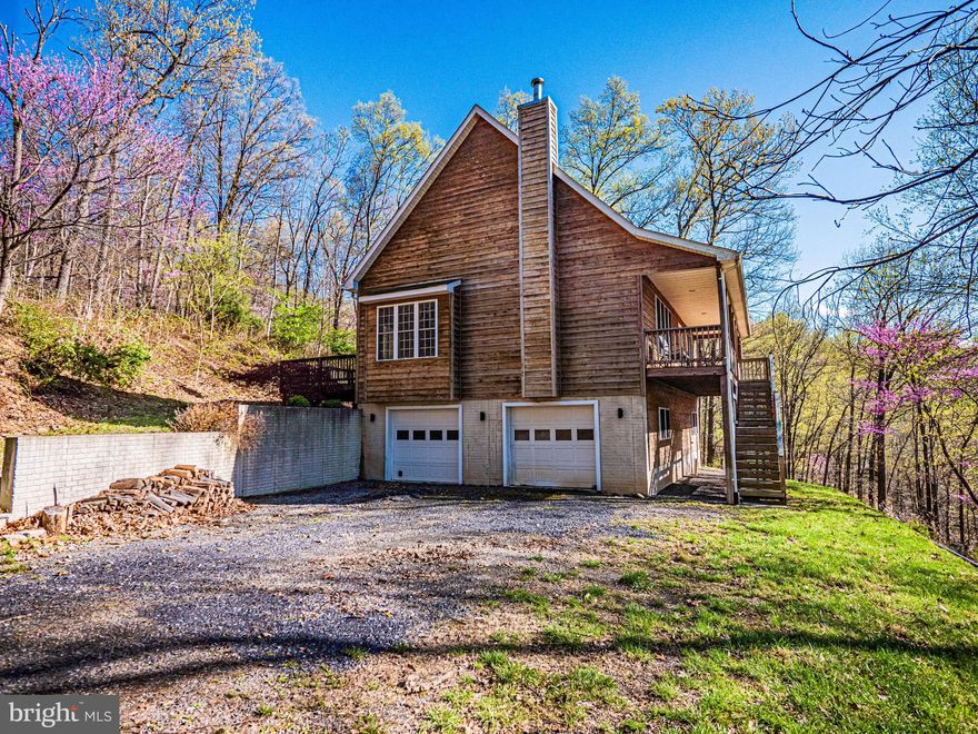 Gorgeous cedar home sitting on almost 4 acres of pristine land with breathtaking mountain views!! Enormous front porch running the entire length of the house giving you a magnificent view of the countryside. Two-story combination kitchen/family room with cathedral ceilings, gleaming hardwood floors, a full-height stone hearth with a wood stove, a walk-out to the back deck, a large center island, pendant lighting, and stainless steel appliances. Main level laundry room right off the kitchen!! Two spacious main-level bedrooms with ample closet space both share a full modern hallway bathroom with tiled floors, an upgraded vanity, and a tub/shower with tiled walls. The entire upper level consists of the primary bedroom with a walk-in closet and an ensuite bathroom with a dual sink vanity, shower stall, and jetted jacuzzi. Cozy basement with entrance to the oversized two-car garage, a utility/storage room, and a small rec-room with luxury flooring and a walk-out to the side yard. Convenient shed and fenced-in area capable of holding livestock!! Beautiful Mountain lake with kayaking and fishing available!! If you are looking for a quiet mountain community, you've come to the right place!! THE HOUSE WILL CONVEY IN AS-IS CONDITION AND NEEDS JUST A LITTLE TENDR LOVING CARE, BUT PRICED APPROPRIATELY!!