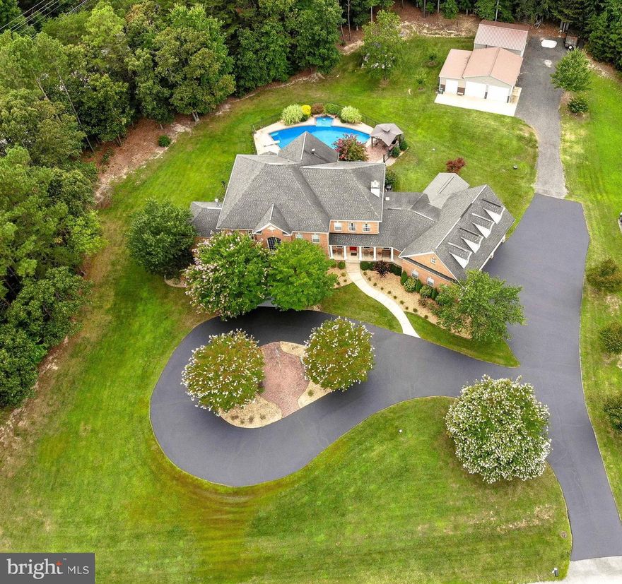 Truly a rare find.  Almost 10,000 sq feet of stunning living space that has been maintained to a level not often seen.  Every square inch is perfection.  From the gorgeous brick exterior to every mechanical system in the house, all is either newer or in mint condition.  This is the largest home in the community and was once the model home, which means it has all the bells and whistles!   Gourmet kitchen includes granite counters, custom cabinetry, 6 burner gas stove, double ovens, two side-by-side refrigerators and a stand-alone ice maker.  The open family room and separate office include custom woodwork that will take your breath away.  There is a full in-law suite on the main level complete with sitting area, full bath and a private screened porch.  Nearby is the laundry center and mud room.  On the upper level is the spacious owners' suite with its own gas fireplace, coffee bar, private bath and a spectacular walk-in closet.  3 additional bedrooms sit on the upper level.  They are spacious and bright, 2 with private access to full baths.  If you enjoy entertaining, the lower level is something to behold.  Expansive with an enormous 2nd kitchen w/ gorgeous counters and cabinetry,  a theatre  room and a spectacular cherry wood wall unit w/ a fireplace at the center.  Nearby is a workshop space and covered steps that lead outside. The outside is a true oasis.  Centered around a fully fenced swimming pool - all newly tiled, heated and salt water.  The spectacular covered stone patio and 2 gazebos bring peace and shade.  Two outbuildings provide all the space you need for any hobby or storage. Both have concrete floors and electricity w/ professional lighting.   Home is located on a tranquil 2 acres yet close to shopping, sought after schools and only a 30 minute drive to Washington DC and 20 minutes to Patuxent River Naval Station. Truly a rare find.