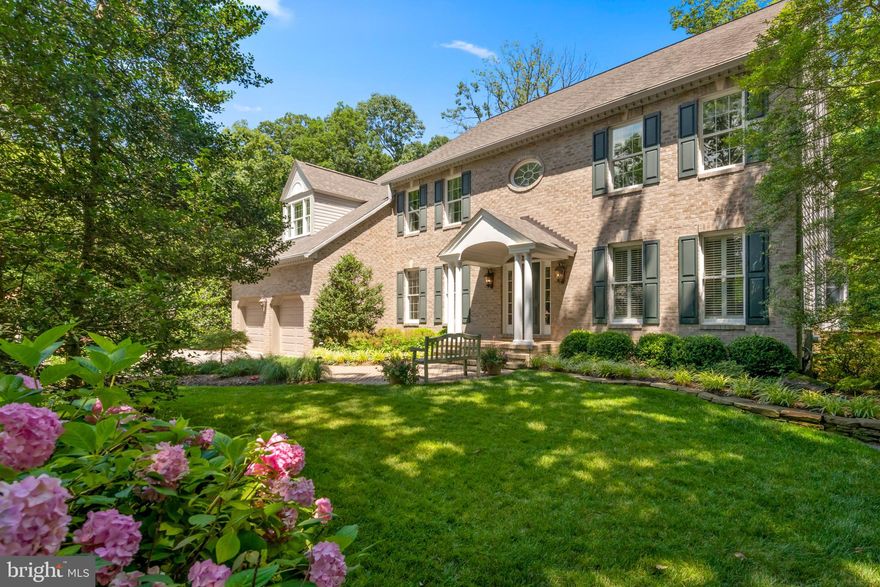 Exceptional opportunity for Buyers seeking a warm and gracious residence that has been continuously upgraded with the finest of materials and meticulously maintained. Set amongst lush landscaping on almost half an acre, this brick colonial  offers approximately 5400 square feet of comfortable living spaces, enhanced with thoughtful details inside and out. Enjoy the expansive deck, stone patio and custom hardscape all backing to Quiet Waters Park.
Offering an elegant 2-story entry, a great room with custom built-ins, a Mendota Gas Fireplace and a motorized TV mount and an incredible kitchen with sitting area with bar that boasts granite and walnut countertops, custom Bentwood cabinetry, 6 Burner Wolf stove/oven & microwave, Sub Zero refrigerator, wine cooler, warming drawer as well as spacious custom pantry with adjacent laundry area. The main level also includes hardwood floors, a generously sized dining room with moldings and Nierman Weeks chandelier and two offices. The bedroom level with an open gallery offers 4 bedrooms and 3 renovated baths including a spacious primary suite with wood floors, a stunning marble bath with soaking tub and multi head shower, sitting room and two custom walk-in closets.  Finished lower level with exercise room, recreation room with pool table, play room/extra bedroom, custom storage, workshop and outside entrance. Custom window treatments, Control 4 and recently installed Audio/Visual system, oversized driveway, storage shed in rear yard.