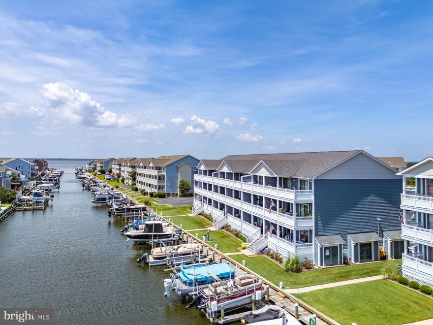 Experience the best of coastal living in this stunning, top floor end unit in sought after Harbour Club. Nestled within the amenity-rich community of Heron Harbour Isle, this home features a blend of upscale features in a resort-style atmosphere.   With panoramic water and skyline views from an expansive, partially covered deck, this residence is a true gem. Beautifully furnished with a coastal flair this well-maintained home is move-in ready. Features include soaring ceilings and a gas fireplace along with many upgrades including granite countertops, luxury vinyl plank flooring throughout and high-end stainless-steel appliances. The primary bedroom suite opens to the waterfront deck while the guest bedroom has its own balcony with views of fountains and lush green space.  Boat slip #40 with a lift is just steps away and conveys with the sale. The lift will accommodate a center console or pontoon boat - perfect for the boating enthusiast.  A large, private storage closet for all your beach gear is located adjacent to the entry door.  Community amenities include a club house with a fitness center, an indoor pool and sauna, tennis courts and three outdoor pools including a lap pool and kiddie pool. All of this just a short walk to the beach, shopping and restaurants. Whether you are looking for a stunning coastal retreat or a high demand investment opportunity, don't miss this opportunity to own a prime location in one of Ocean City's finest communities.