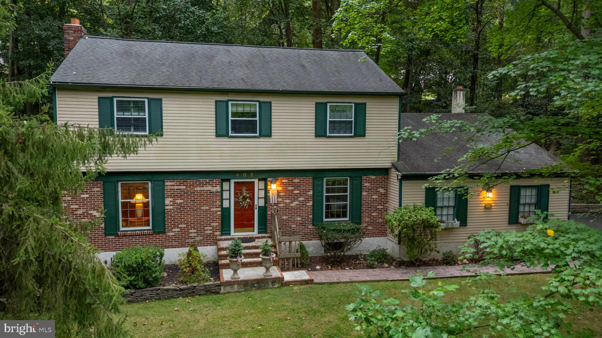 Lovely 4 Bedroom, 2.5 Bathroom Home set on an acre lot in Downingtown. From the moment you arrive the pride of ownership is evident at 402 Norwood Road, from the charming curb appeal framed by mature landscaping to the meticulously maintained interior. Step through the welcoming Entryway, where a tile floor and elegant staircase set the tone for the home's classic style. The updated Chef’s Kitchen is sure to impress with its 5 burner dual fuel double oven, perfect for entertaining. The space also includes white cabinetry, granite countertops, stainless steel appliances, and a spacious eat-in area. Adjacent to the Kitchen, the formal Dining Room features hardwood flooring, abundant natural light, and ample space for hosting holiday gatherings. The large Living Room is equally inviting, centered around a beautiful brick Fireplace. On the opposite side of the home, the cozy Family Room features a full brick wall focal point and second Fireplace in addition to opening on to the Sunroom. The Sunroom features a stunning cedar cathedral ceiling and is flooded with natural light from floor-to-ceiling windows and skylights, making it an ideal spot to relax after a long day. A recently updated Powder Room completes the Main Level. Upstairs, the spacious Primary Suite features a walk-in closet and a tastefully renovated private Bath. The 3 additional Bedrooms on this level are all generously sized and include good closet space and the Hall Bathroom has been entirely remodeled as well. The property also includes an attached 2 Car Garage and the home itself backs to trees providing privacy. In addition, the 18 acres across the street is designated open space. With numerous recent updates throughout, this home blends timeless character with modern comfort. Schedule your private showing today and come experience all that this charming property has to offer first-hand!