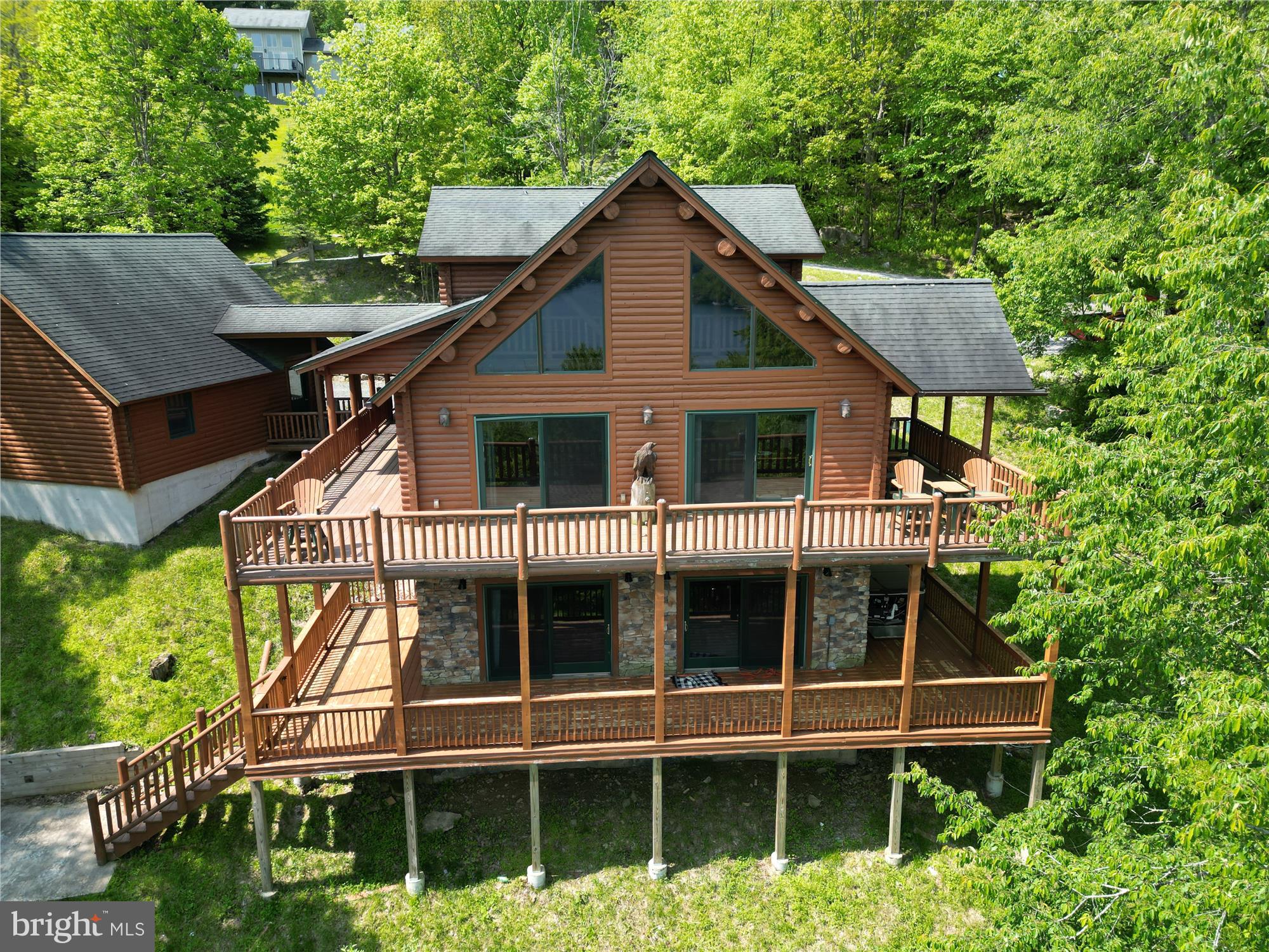 Lake views for days and room to relax in every direction!
Welcome to 198 Grandview Drive, a 3-bedroom, 3-bath log home perfectly perched to capture sweeping views of Deep Creek Lake and the surrounding mountains. With three finished levels of living space, this home blends rustic charm with modern comfort. Hardwood floors span the main and upper levels, while the finished lower level features a family room with a fireplace and a cozy bonus room perfect for a media area, home gym, or extra guest space.
Step outside and soak it all in. Whether you're sipping your morning coffee on the expansive two-level deck, grilling with a lake view, or gathering around the brick firepit on the spacious concrete patio, this outdoor space was made for taking in the sights, sounds, and serenity of Deep Creek. The detached garage includes a conditioned loft ready to become your home office, studio, or additional guest space.
Located in a peaceful community with potential boat slip access through the HOA (subject to availability). Whether you're seeking a vacation home, a short-term rental investment, or your own slice of lake life, this one delivers.
Don’t miss your chance to own a front-row seat to Deep Creek’s beauty. Schedule a showing today!