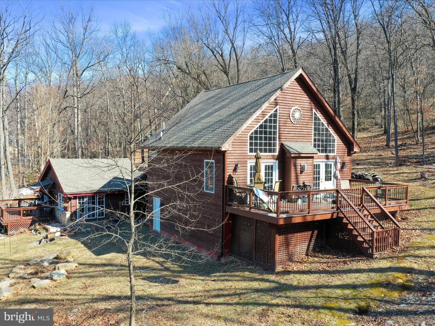 HUGE PRICE REDUCTION! Unique cabin with recent (2016) chalet style addition.  Nestled in the mountain community of Shannondale, this gem sits on over an acre of land. Relax on the multiple decks and enjoy the tranquility nature has to offer. Nearby is the beautiful 55 acre lake, The Mountain Lake Club, Shenandoah River and the Appalachian Trail.   Interior features include Jotul wood stove on main level and gas fireplace on upper level for those crisp mornings and cool evenings.  Remodeled bath with gorgeous freestanding copper tub and separate custom shower.  For that rustic feel, there are exposed beams, knotty pine and oak ceilings.  Hardwood, ceramic tile and flagstone floors, add to the charm of this versatile home.  Don't let this beauty pass you by.