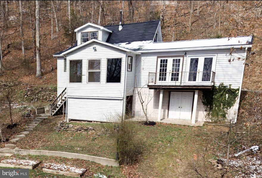 “Springfield Cabin” - Nestled along the hillside in scenic Springfield, West Virginia, this beautifully renovated chalet offers the perfect blend of modern comfort and peaceful country living. Surrounded by just over 10 acres of wooded landscape across two parcels, this private retreat invites you to unwind and take in breathtaking hillside views from nearly every angle.

Step inside to discover a home that has been thoughtfully and thoroughly updated. Fresh paint and new carpeting create a bright, welcoming interior, while the completely remodeled kitchen features brand-new cabinets, countertops, and appliances—ready for everything from quiet mornings to entertaining guests. The fully renovated bathroom offers a clean, modern feel with updated fixtures and finishes.

This charming home includes two comfortable bedrooms and a versatile bonus loft space on the second level—perfect for a guest area, reading nook, or creative studio. A renovated utility room on the main level doubles as a functional office space, providing flexibility for remote work or hobbies, as well as laundry.

One of the home’s standout features is the sunroom, filled with windows that frame picturesque views of the front yard and surrounding landscape. It’s an ideal spot to enjoy your morning coffee, watch the seasons change, or simply relax in natural light.

Practical upgrades add peace of mind, including a new roof and gutters, as well as an insulated unfinished basement offering ample storage or future expansion potential.

Outside, the property truly shines. The expansive acreage is dotted with mature trees for privacy and includes numerous fruit trees, adding charm and the opportunity for homegrown harvests. Nature lovers will appreciate access to a community fishing pond, perfect for quiet afternoons spent outdoors.

Whether you’re seeking a full-time residence, a weekend getaway, or an investment in serene mountain living, this turnkey chalet delivers comfort, beauty, and space to breathe—all in a tranquil West Virginia setting.