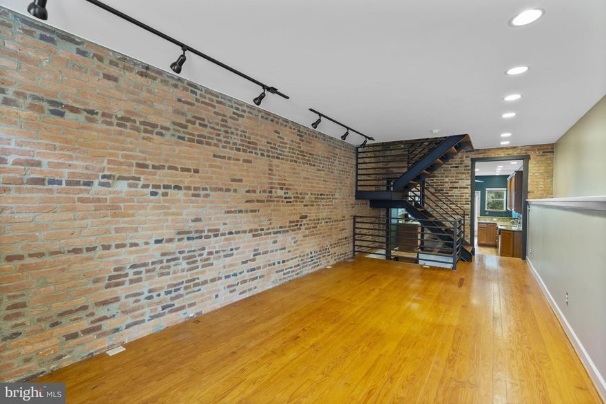 Tucked away on a tree‑lined block in historic Locust Point, this beautifully renovated rowhome blends classic Baltimore charm with modern convenience. Behind the handsome brick façade you’ll find an open‑concept main level with rich hardwood floors, exposed brick accent walls and a sleek, open‑riser staircase. The living and dining areas flow effortlessly into a renovated chef’s kitchen featuring warm wood cabinetry, granite countertops, stainless‑steel appliances and a tile backsplash. Large glass doors lead to a fenced patio with stone pavers, string lights and bamboo screening—perfect for outdoor dining and entertaining. The upper levels host three spacious bedrooms, three full baths and two powder rooms. The owner’s suite is spacious and provides a walk‑in closet and an en-suite bathroom with a large walk-in tiled shower. Additional bedrooms offer generous closet space, hardwood or carpeted floors, large windows and exposed brick or ductwork that add industrial flair. A second full bath features chic tile work, jacuzzi tub and plenty of storage space. There's also an  upper‑level wet bar/entertaining nook for easy rooftop access, half bath and bonus room that is perfect for a home office, second living room or guest area. The finished basement expands the living area with tiled floors, a half bath and space for a home gym, office or guest suite. The crawlspace area is perfect for storage and is dry and runs the entire back portion of the house. Laundry is conveniently located on the bedroom level, and there’s a mechanical room for extra storage. Both HVAC systems have been recently updated for peace of mind and comfort. Crowning the home is a sprawling rooftop deck—an urban oasis with panoramic views of the Baltimore skyline, harbor and neighborhood rooftops. Whether you’re enjoying morning coffee or hosting sunset gatherings, this space offers a front‑row seat to everything Locust Point has to offer. Located just blocks from the waterfront, Fort McHenry, community parks and the shops and restaurants of McHenry Row, this property provides easy access to I‑95, downtown and Federal Hill while retaining a quiet neighborhood feel. With its blend of historic character, modern updates and prime location, this home is a must‑see for anyone seeking the best of city living.