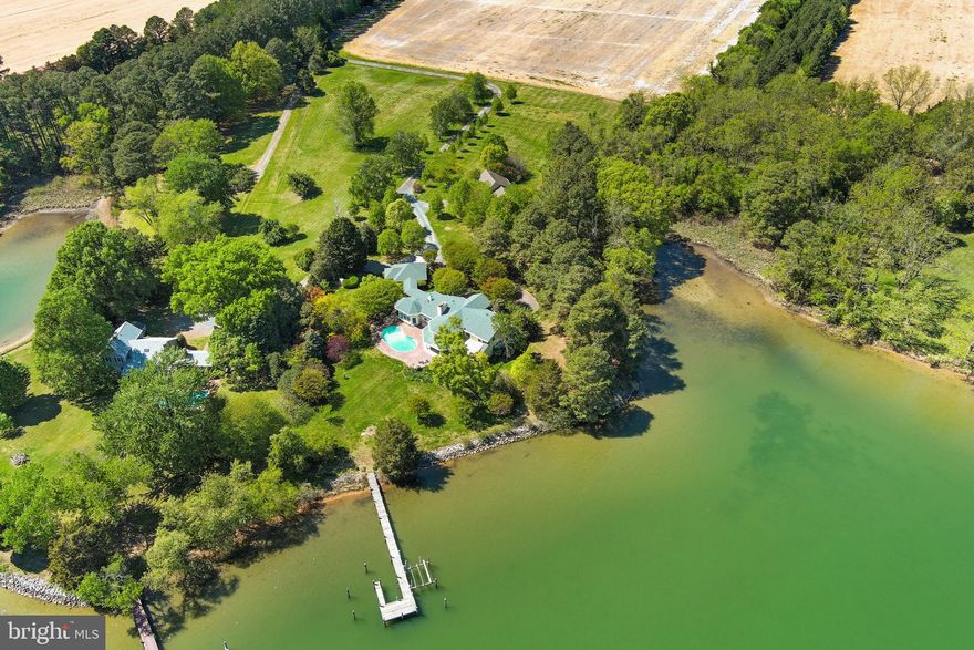 ‘Eagle’s Nest’ is an exceptional waterfront retreat overlooking Island Creek, just minutes from historic Oxford. Prime location with guest house and deep water (6.5' MLW). 
Privately sited on more than four acres amid mature trees and meticulously landscaped grounds, this impressive main residence (5324 SF)—completely rebuilt by Ilex Construction in 2008—offers four bedrooms, four full baths, and two half baths. Every room is generously sized and thoughtfully designed to capture expansive water views while providing elegant yet comfortable living.

The main level features beautifully appointed living spaces, including a formal living room with coffered ceiling, wood-burning fireplace, custom built-ins, wet bar, and sliding doors opening to the waterside patio. A formal dining room, enclosed by French doors, offers an inviting setting for entertaining.

At the heart of the home, the gourmet kitchen showcases a cathedral ceiling, large center island, top-of-the-line appliances, gas fireplace, spacious walk-in pantry, and custom built-ins—creating a warm and functional gathering space. The adjoining sunroom is filled with natural light and features vaulted ceilings, slate tile flooring, and sweeping water views, with glass doors opening to the patio and pool area. Nearby, a well-equipped mudroom, laundry room, and half bath add everyday convenience, along with a covered breezeway to the two-car garage.

The desirable main-level primary suite serves as a private retreat with tranquil water views, dual walk-in closets, and a luxurious en suite bath. Just off the primary suite corridor, a private office with custom built-ins and an additional powder room enhance the home’s thoughtful design.

Upstairs, three generously sized guest bedrooms each include en suite baths. A comfortable sitting area opens to a balcony overlooking Island Creek—an ideal place to relax and take in the serene setting.

In addition, a coveted one-bedroom, one-and-a-half-bath guest house (968 SF) includes a full kitchen, living room, and attached two-car garage—perfect for visitors, extended family, or flexible use.

Outdoor living is equally impressive, highlighted by a gunite swimming pool, expansive brick patio, mature landscaping, and extensive hardscaping designed to complement the waterfront setting. The private pier features two slips and a boat lift with 6.5' MLW along a protected, riprapped shoreline.

‘Eagle’s Nest’ presents a rare opportunity to enjoy refined Eastern Shore waterfront living just moments from Oxford.

New roof on main house (2025). New pool cover: Aqua pool service contract paid for-2026