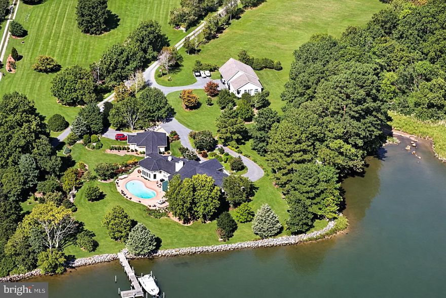 ‘Eagle’s Nest’ is an exceptional waterfront retreat overlooking Island Creek, just minutes from historic Oxford. Prime location with guest house and deep water (6.5' MLW). 
Privately sited on more than four acres amid mature trees and meticulously landscaped grounds, this impressive main residence (5324 SF)—completely rebuilt by Ilex Construction in 2008—offers four bedrooms, four full baths, and two half baths. Every room is generously sized and thoughtfully designed to capture expansive water views while providing elegant yet comfortable living.

The main level features beautifully appointed living spaces, including a formal living room with coffered ceiling, wood-burning fireplace, custom built-ins, wet bar, and sliding doors opening to the waterside patio. A formal dining room, enclosed by French doors, offers an inviting setting for entertaining.

At the heart of the home, the gourmet kitchen showcases a cathedral ceiling, large center island, top-of-the-line appliances, gas fireplace, spacious walk-in pantry, and custom built-ins—creating a warm and functional gathering space. The adjoining sunroom is filled with natural light and features vaulted ceilings, slate tile flooring, and sweeping water views, with glass doors opening to the patio and pool area. Nearby, a well-equipped mudroom, laundry room, and half bath add everyday convenience, along with a covered breezeway to the two-car garage.

The desirable main-level primary suite serves as a private retreat with tranquil water views, dual walk-in closets, and a luxurious en suite bath. Just off the primary suite corridor, a private office with custom built-ins and an additional powder room enhance the home’s thoughtful design.

Upstairs, three generously sized guest bedrooms each include en suite baths. A comfortable sitting area opens to a balcony overlooking Island Creek—an ideal place to relax and take in the serene setting.

In addition, a coveted one-bedroom, one-and-a-half-bath guest house (968 SF) includes a full kitchen, living room, and attached two-car garage—perfect for visitors, extended family, or flexible use.

Outdoor living is equally impressive, highlighted by a gunite swimming pool, expansive brick patio, mature landscaping, and extensive hardscaping designed to complement the waterfront setting. The private pier features two slips and a boat lift with 6.5' MLW along a protected, riprapped shoreline.

‘Eagle’s Nest’ presents a rare opportunity to enjoy refined Eastern Shore waterfront living just moments from Oxford.

New roof on main house (2025).