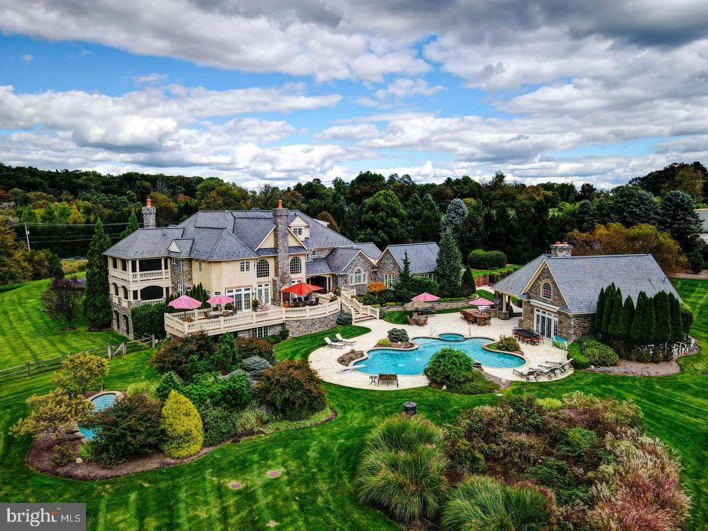This stately five-bedroom, eight-and-a-half bath manor has everything you need to live a lavish lifestyle. As you drive up the winding driveway to the grand main entrance, you are surrounded by yards of lush green grass, beautifully manicured hedges, and vibrant foliage in your front gardens. Entering through the charming wooden front door, you are greeted by an exquisitely tiled foyer detailed with a two story ceiling and gorgeous crown molding. Immediately to your right you come across an intimate living room accented with hardwood flooring, a cozy gas fireplace, crown molding, and an abundance of natural light. Directly attached to the living area is a splendid covered porch completed with a gas fireplace, phantom screening, two ceiling fans, and tile-work.
Across the hall from the living room sits a vast dining room boasting recessed lighting, high ceilings, hardwood floors, and oversized windows. Through the dining room sits the gourmet kitchen which features glistening granite countertops, stainless steel Wolf stove and oven, SubZero refrigerator and freezer, two dishwashers,and broad island countertops.
Moving along on the first floor you come across the second room with a two story ceiling, the main family room. Nestled in the back of the home sits this warm and inviting secondary living room boasting two-story ceilings, a delightful view of the backyard, cozy gas fireplace, and crown molding. A great room / media room complete with a wet bar and kitchenette, can be found on the other side of the main level with direct access to the back yard. Rounding out the first floor is an indoor endless pool, a home office, lofty sun room, and one-and-a-half baths.
As you walk up the sweeping wooden staircase to the second floor you are welcomed into the primary suite masterfully detailed with cathedral ceilings, a cozy sitting area, covered porch with phantom screens, two indoor and outdoor gas fireplaces, and dual walk-in closets. The exclusive ensuite bath features two vanity areas, a romantic champagne jacuzzi, a large glass enclosed double walk in shower, and a convenient built-in beverage refrigerator. Three suitably sized bedrooms can also be found on this level, each with their own walk-in closet and full bathroom, two desk work areas, and a laundry room.
The third level hosts a sizely in-law suite/apartment which can be accessed by the stairs or the elevator. This top level includes a large bedroom suite with a separate living area, two walk-in closets, additional storage area, and a built-in beverage refrigerator.
The extravagantly large lower level of this home has everything you are looking for to host your next gathering of friends and family. Escape the sticky floors of a movie theater and stay at home in your personal movie room, entertain the rush of a game night in your fun-packed game room equipped with a stage, bring the thrill of Atlantic City to you in your separately ventilated poker room, throw out your gym membership and enjoy the use of your exclusive home gym, and host your own night out in your personalized bar and wine cellar. Finalizing the lower level is a full bathroom and an individual studio accompanied by a private entrance, full bathroom, and a washer and dryer hookup.
Last but certainly not least, we move outside to the backyard that has the feeling of your own private resort. The backyard hosts two refreshing in-ground pools highlighted by a water slide. Next to the pool area sits the pool house stocked with a full kitchen, washer and dryer, full bathroom, spacious living area, and an indoor / outdoor fireplace. Rounding out the backyard is a large covered patio, full outdoor kitchen, sprinkler system, and home generator.
Located in East Goshen Township directly in between Route 30 and Route 3, this home provides easy access to major highways and public transportation, making commuting from this home a breeze.
