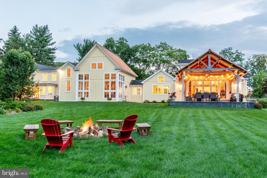This stunning unique home is a true labor of love, meticulously renovated to seamlessly combine rustic charm of an original vintage barn with luxurious details. With a focus on quality and efficiency, every corner of this home is filled with thoughtful design choices. The main stone entry graces a bluestone landing and period style gas light fixtures leading to a stunning stone portico and is greeted by 10’ custom mahogany arched double doors that are welcoming with an inviting vineyard feel that will have you believing you are somewhere in Sonoma! The main living area boasts soaring cathedral ceilings, white oak random width floors, cozy wood burning stone fireplace and serene panoramic views. The open floor plan of the great room, dining room and kitchen is perfect for hosting guests, with post & beam, exposed rustic mortise and tenon barn details adding character and warmth. Featuring top-of-the-line appliances and two massive granite islands for ample workspace & storage and seating for eight,  a huge walk-in pantry behind a reclaimed vintage barn door, and a designated zone for coffee making and wine storage, the kitchen is a chef’s dream featuring two 30" Sub Zero refrigerators with freezer drawers built into the wall of custom cabinets. A Wolf dual-fuel 6-burner range & griddle and Wolf Pro-Liner exhaust are built into a stone wall and flanked by a Mugnaini fire brick oven complete with wood storage below. Massive Nanawall glass bifold doors that open completely to a dramatic exposed beam covered bluestone patio overlooking the side & rear yards with views of the adjacent 98+ acre preserved farm next door, are all perfect for a wonderful al fresco dining experience.  The original circa 1870’s farmhouse wing offers the main floor primary suite, is a true sanctuary, with an attached spa-like bathroom, having two sinks, soaking tub, travertine heated flooring & a generous glass enclosed frameless shower, 2 designer walk-in closets, a sitting area and a cozy fireplace with access to the front & side covered porches. The remaining three junior suites on the second level each have their own bathrooms and loads of closet space, providing comfort and privacy for all. A flex room, on the main level, with an en-suite bath currently used as an in-home office, has a private doorway with outside access. The gorgeous designated office space offering a wall of windows with panoramic views and a cathedral ceiling is a dream come true!  The home is equipped with modern amenities including multi-zone HVAC, a security system, and WIFI-controlled sound. The six-car garage is finished and heated, having a work sink and an above loft suite that includes a spacious bedroom with sweeping views, a gourmet kitchen with soapstone counters, a spacious great room w/gas faux wood stove, a full bathroom & laundry, perfect for hosting overnight visitors or as a personal private retreat. With views of surrounding farmland, and open lots there is plenty of space for a pool, Newtown schools, and a short distance to New Hope’s restaurant scene, this home is a dream come true!