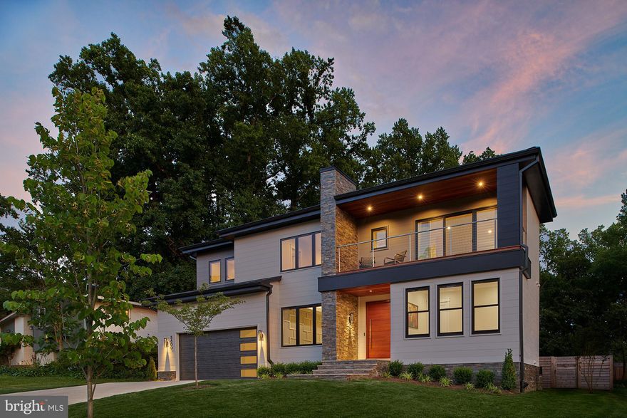Elegant and award-winning, this custom contemporary residence is a true standout in the heart of Bethesda. Designed by Elie Ben Architecture and built by Carter, Inc. in 2019, this sophisticated home was honored with Montgomery County’s “Custom Contemporary Award of Excellence” and featured in Home & Design magazine for its timeless design and exceptional craftsmanship.

Set on a manicured 0.23-acre lot, the home offers approximately 6,280 square feet of finished living space across three levels. A striking 5’ wide White Oak pivot door welcomes you into a light-filled interior where 10-foot ceilings, wide-plank White Oak floors, and expansive glass openings define a thoughtfully curated floor plan. The open-concept main level includes a guest suite or private office with an adjacent full bath, a beautifully detailed dining room with elegant moldings, and a custom wine room positioned between the kitchen and dining area. The morning room, tucked off the kitchen, is filled with natural light and framed by oversized custom windows. The great room is defined by a sleek gas fireplace as well as panoramic 8-foot-tall, 16-foot-wide sliding glass doors that open to a large limestone patio—measuring 38 by 15 feet—complete with a built-in summer kitchen featuring a grill, burner, pizza oven, and storage.

The kitchen itself is a chef’s dream, outfitted with top-tier Thermador appliances including a 48” gas range with griddle and dual ovens, two knock-to-open dishwashers, a built-in refrigerator and freezer, and a second wall oven and microwave combo. A large butler’s pantry offers additional prep and storage space, with a dedicated beverage fridge and a second fridge in the walk-in pantry.

Upstairs, a central family lounge opens to a balcony, creating an inviting and flexible living space. The primary suite features a large walk-in closet with custom built-ins and a luxurious primary bathroom. Three additional bedrooms complete the upper floor, an en-suite guest bedroom and two spacious bedrooms share a Jack and Jill bathroom. Also on the upper floor, a well-equipped laundry room.

The finished lower level is versatile and spacious, offering a guest suite with full bath, a large recreation room with linear fireplace, a wet bar with beverage fridge, and designated areas for a game room and craft space.

Additional highlights include a two-car garage with epoxy flooring, EV charging outlet, and custom storage; custom Hunter Douglas window shades; pre-wired speakers and CAT-6 in every room; dual-zone high-efficiency HVAC; and a 400 AMP electrical system with generator-ready sub-panel.

Minutes from downtown Bethesda, this sophisticated home offers a unique design that balances architectural interest with everyday functionality.