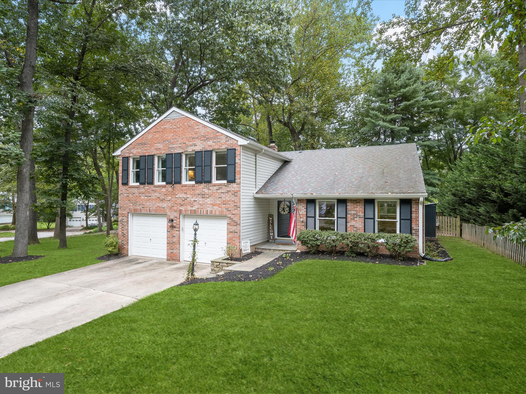 Nestled on a wooded cul-de-sac street, this beautiful brick front split-level home combines timeless design with thoughtful updates throughout. A stone walkway leads to the front door, where the foyer welcomes you with a custom drop zone complete with hooks and bench storage. To the right, the spacious living and dining rooms create an inviting flow for entertaining, with the dining room opening seamlessly to the kitchen. Brightened by a skylight, the kitchen is a true highlight with stainless steel appliances including a double oven, granite counters, undermount cabinet lighting, and a cozy breakfast area. A sliding glass door opens to the composite deck with vinyl railings, extending your living space outdoors. Back inside, just a few steps down, the family room offers a warm retreat with a fireplace framed by built-in bookcases and another sliding glass door leading to the paver patio, perfect for gatherings. This level also connects to the two-car garage, complete with a custom workbench and shelving, as well as the laundry room with utility sink. Upstairs, the primary suite is generously sized and thoughtfully designed with a sitting area, a wall of closets, and an en-suite bath featuring a double sink vanity, soaking tub, and floor-to-ceiling tiled shower. Originally the sitting area was a fourth bedroom and could easily be converted back if additional bedrooms are needed. Two additional bedrooms and a full bath complete the upper level, offering comfort and flexibility. The fully fenced backyard provides a private retreat with both a deck and patio for outdoor living. Whether relaxing or hosting guests, this space is designed for versatility. With luxury vinyl plank and carpet installed in 2020, stylish lighting fixtures, smart lighting, a recently replaced roof, gutter guards, three skylights, and a newer furnace, this home is ready to be enjoyed with peace of mind. Living here means more than just a beautiful home, it is a lifestyle. Enjoy everything downtown Columbia has to offer, from lakeside strolls around Lake Kittamaqundi to live performances at Merriweather Post Pavilion. The Mall in Columbia, a wealth of restaurants, seasonal festivals, and miles of walking trails ensure there is always something to experience. And with easy access to U.S. Route 29, I-95, and MD 32, commuting to Baltimore, Washington, D.C., or Annapolis is both convenient and efficient. This home truly blends comfort, style, and location in one remarkable package.