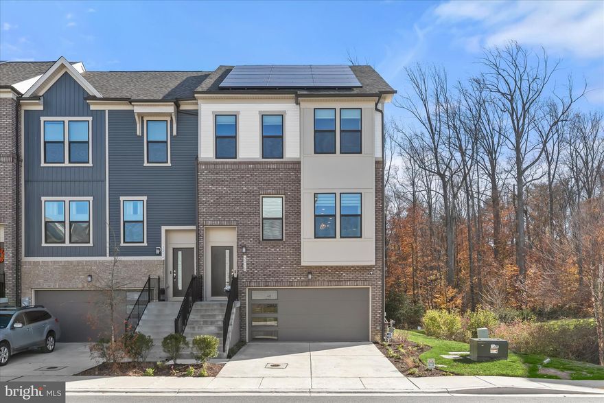 Welcome to 3316 Watershed Boulevard, an upgraded Isleton townhome on a premier corner lot within the Watershed community of Anne Arundel County. This original builder-upgraded homesite offers added privacy and abundant natural light, buffered by a professionally landscaped garden maintained by the HOA. The home backs to protected open space near the Patuxent Wildlife Refuge, providing lasting wooded views preserved from future development.

A bright split-foyer layout connects the main living level and the flexible lower level. The main living spaces are designed for everyday comfort and entertaining, anchored by a well appointed kitchen with 42” white recessed panel cabinetry, quartz countertops, a large center island, pantry storage, and full depth cabinetry above the refrigerator. Stainless steel appliances, an undermount sink with pull out sprayer, recessed LED lighting paired with installed pendant fixtures over the center island complete the space.

The dining area features a statement chandelier, while adjacent living and gathering areas feel open and inviting. The light-filled sunroom opens to a private deck overlooking the wooded backdrop, creating an easy indoor-outdoor connection.

The upper level offers three generously sized bedrooms with plush, soil-resistant carpeting and ample closet space. The owner’s suite features a spa-inspired bath with quartz vanity countertops, white cabinetry, polished chrome fixtures, ceramic tile flooring, and a tiled shower with built-in seating. Additional bathrooms include quartz-topped vanities and coordinated finishes.

The walk-out lower level adds flexibility with a private bedroom and dual-entry en-suite full bath, ideal for guests, multi-generational living, or a home office.

Thoughtful comfort upgrades are found throughout the home, including installed, remote-controlled ceiling fans in all four bedrooms and the sunroom, along with custom window blinds on every window, providing enhanced comfort, privacy, and light control from day one. 

A high-capacity, grid-connected solar system with extensive roof coverage delivers consistently lower electric costs and the opportunity to earn SREC income. Additional energy-efficient features include low-E insulated windows, 100% LED lighting, and a Wi-Fi-enabled smart thermostat.

The two-car garage includes a 240-volt outlet, making it fully EV-ready. Watershed amenities include community centers, fitness facilities, pools, dog parks, gardens, and 13 miles of trails, with convenient access to Washington, DC, Baltimore, and Annapolis.