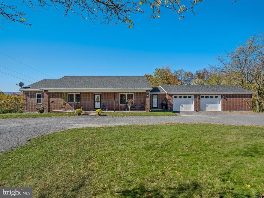 Start your mornings with breathtaking sunrises over Sleepy Creek Mountain from the comfort of your front porch—perfect for savoring your coffee while soaking in the natural beauty. This quality-built, one-owner home, constructed with all brick and stone, offers unique craftsmanship with stone masonry throughout—far from your typical cookie-cutter design.
Located in southern Morgan County, this home provides convenient access to Winchester, VA (just a 30-minute commute), Martinsburg is a 25 minute scenic drive via Shanghai Rd and downtown Berkeley Springs (only 20 minutes away), where you can enjoy local events and activities. Plus, it’s an easy-to-access location off Winchester Grade Rd, ensuring peace of mind during winter.
The home features 5 potential bedrooms (3 on the main level, 2 in the basement) and 2.5 baths. The open kitchen is equipped with beautiful hickory cabinets and a built-in office area, flowing seamlessly into the living room and an 18x18 family room with a cozy fireplace. A spacious laundry room and an oversized 24x36 double garage provide ample storage space for all your needs.
On the lower level, you’ll find a second finished 18x18 family room with rich paneling and flagstone accents, complete with a woodstove for a warm, cabin-like atmosphere. The basement also offers additional unfinished space, ready for your customization—perfect for extra storage or creating more living areas.  Frontier recently upgraded fiber optic internet.
Don’t miss out on this mountain retreat that blends quality craftsmanship, comfort, and convenience. 
Additional adjoining 2.19 acre lot may be available by separate owner/contract/purchase.