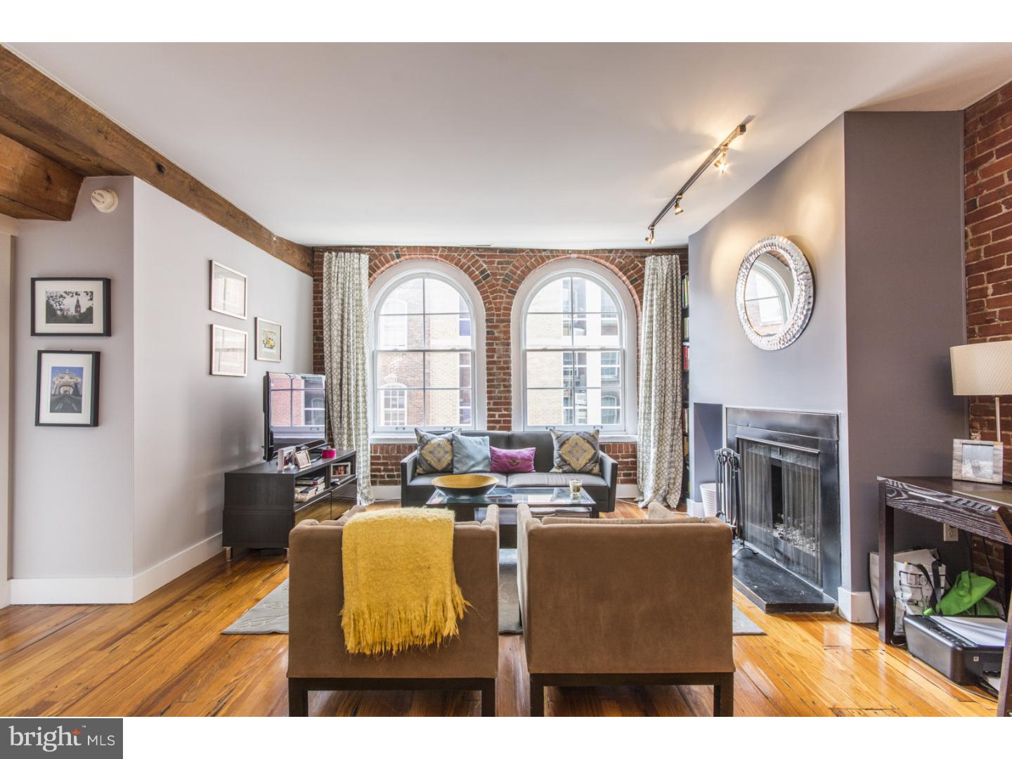 Historic charm meets modern amenities in this stunning condo located in a boutique elevator building in the heart of Old City. Situated in a former textile factory, this home has original hardwood floors, exposed brick and a working wood-burning fireplace while enjoying the modern amenities of a European-style kitchen with stainless appliances, in-unit Bosch washer/dryer and bathroom with tumbled marble finishes. The spacious great room is perfect for entertaining in the home. Large arched windows provide abundant natural light throughout.