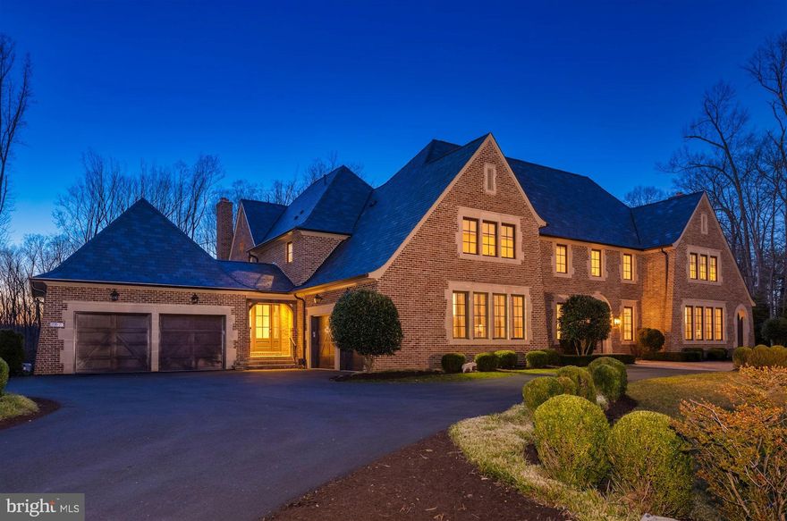 Originally inspired by Charles Voysey’s English Manor homes, this 2016 Artisan Custom Homes built estate is sited on 2.29 bucolic acres with truly beautiful vistas. This home affords over 11,000 SF of luxury living  in the private community of Bull Neck, accessed by Boyle Lane private access to Scott’s Run and its network of hiking trails along the Potomac. Graciously scaled rooms yield stunning window views from nearly every vantage point and open up to exterior spaces that include a stunning infinity pool with waterfall hot tub, flanked by an expansive, flat yard.   The thoughtful floorplan with five bedrooms on the upper level includes dual wings connected by a gallery hall that provide seamlessly for formal entertaining and casual family living.  Beautiful, character-grade millwork and cabinetry and stunning transitional elements complement each other at every turn. Among these are reclaimed wood beams, handsome stone fireplaces, casual wall and ceiling paneling, cool toned marbles, and modern light fixtures and hardware.  A natural stone interior gallery wall anchors the home with multiple sets of French doors that lead to the pool terrace. Two stair halls connect to the upper and lower floors, and walls of windows invite an inpouring of natural light. The entry hall’s views bring the outside in and continue through the formal dining room as well as the formal living room with its masonry fireplace and antique mantel, paneling and custom barn doors that lead to the library. An idyllic work-from-home space, the library is fully paneled with quarter sawn-oak, built-ins and a window seat.  The home’s formal wing blends seamlessly with the casual wing via an expansive transitional stair hall with v-groove paneling and sliding barn doors which opens to the incredible butler’s pantry with wine storage, kitchen, breakfast room, and great room. All design choices serve to unify the straight, clean lines of modernity with the rich hues of antique solid-wood beamed ceilings, including the kitchen’s reclaimed 100-year old beams originating from the original property on Bull Neck Run.  A future elevator shaft, multiple pantries, mud room with private home-office or homework room, a family powder room, and two separate two-car garages complete the main level.  The 43’ infinity gunite pool with 28’ infinity basin is surrounded by Ardiglulio Porcelain tile (specifically chosen for its non-slip properties and cool to the touch surface) with an individual waterfall spa hot tub is easily accessed from both the casual and formal wings of the home. An outdoor kitchen and fire pit as well as an expansive wooded play area and flat yard add to the exterior amenities and complete the ideal property.  The upper foyer landing doubles as cozy reading nook, and the primary suite is its own paradise with a sitting room, vaulted wood-beamed ceiling, expansive windows, three custom closets, a heated bathroom floor, and incredible spa bath with vaulted ceiling and v-groove accents. Comprising the 2nd floor are 4 other separate bedroom suites with en-suite bathrooms and walk-in closets, and a large laundry room, all continuing the theme of natural material tile and vanities.  The fantastic lower level greets family and guests with a beautiful and unique stone bar featuring custom cabinets, and antique wood counter accent, and  custom light fixture. The bar area leads to a day-light lounge and recreation room, with 42” masonry fireplace, and a game room with tray ceiling, a powder room, a custom nerf-gun armory and it walks-out to another patio space. The alternate wing of the lower level is comprised of a custom exercise room with rubberized gym floor, wall mirrors, and a glass wall that divides it from a peaceful yoga/spa/sauna room with bamboo flooring. A private guest bedroom and its en-suite bath complete this level.  All this along with convenient access to Tysons, 495 & GW Parkway, for effortless access to DC.