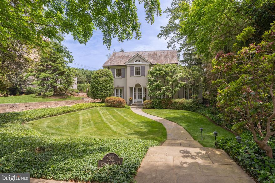 Classic Colonial Elegance in Prestigious Wesley Heights

Nestled in one of Washington, DC’s most coveted neighborhoods, this deceptively spacious classic 1927 Colonial offers timeless elegance, modern amenities, and exceptional craftsmanship across 5,765 finished square feet. Located in the heart of Wesley Heights, this distinguished residence combines traditional architectural beauty with sophisticated living.

A gracious foyer opens to a grand living room on the right—an expansive space with a stately fireplace and an elegant sitting area framed by French doors. To the left, a cozy family room with its own fireplace offers a warm retreat. The formal dining room sits just beyond the living room, wrapped in French doors that flood the space with natural light and provide serene views of the private backyard—a regal setting for entertaining.

The chef’s kitchen is both stylish and functional, featuring limestone floors, abundant custom cabinetry, and exquisite Costa Esmeralda and Fantasy granite countertops. The circular breakfast nook, surrounded by floor-to-ceiling Pella windows, is bathed in light and features heated floors for year-round comfort. A designer powder room with a custom stenciled floor by artist Marcus Pluntke completes the main level.

Upstairs, the second floor boasts four well-appointed bedrooms, including a luxurious primary suite. This private retreat includes two walk-in closets, en-suite bathroom, a stunning circular sitting room with gas fireplace, walls of windows with privacy shades, a private office, and a secluded balcony overlooking the backyard.

The third floor provides three additional bedrooms and a full bath with skylight, plus a spacious bonus room—perfect for guests, play, or creative use.

Outdoors, a professionally landscaped backyard offers a flagstone patio, green space, and privacy-enhancing plantings, all supported by a full irrigation system. A two-car garage is conveniently attached via portico.

With 9-foot ceilings throughout most of the home, abundant natural light, and an ideal balance of formal and informal spaces, this residence is an extraordinary offering in one of DC’s most refined enclaves.

A rare opportunity to own a classic yet expansive home in Wesley Heights.