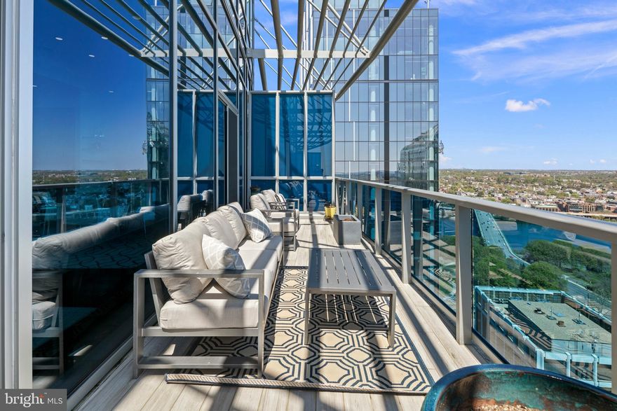 Rarely available, this top-floor penthouse at Turnberry Tower is the pinnacle of elevated living in Arlington. Perched high above the city in one of the region’s most coveted full-service buildings, this distinctive residence offers panoramic vistas of Georgetown, the Potomac River, and Washington, DC. A private elevator opens directly into more than 2,600 square feet of sophisticated interiors, where floor-to-ceiling glass frames sweeping views and bathe the home in natural light, easily tailored at the touch of a button with automated blinds throughout the residence. A grand terrace balcony stretches the length of the home—perfect for both intimate evenings and elegant entertaining. Inside, three spacious bedrooms and three luxurious bathrooms provide the ideal blend of comfort and refinement. The primary suite is a true sanctuary featuring a marble-clad bath with soaking tub, walk-in shower, dual vanities, heated towel rack, and water closet, alongside a fully built-out walk-in closet. The secondary bedroom offers a glass-enclosed steam shower. Both the primary and secondary bedrooms enjoy private access to the terrace through expansive glass doors, allowing a seamless connection to the panoramic views and fresh air. The gourmet kitchen is a statement in design and functionality, with sleek Snaidero cabinetry, Miele wall ovens and built-in coffee system, Sub-Zero refrigeration, and wine fridge. For the discerning collector, a dedicated, temperature-controlled wine room offers ideal storage for your prized vintages. Additional features include a separate laundry room with utility sink and storage, soaring 11-foot cove ceilings, and gallery-style walls ready for fine art. Turnberry Tower delivers an unparalleled lifestyle, with white-glove service including valet, 24-hour concierge, doormen, an indoor pool, spa, fitness center with sun terrace, private screening room, and stylish club lounge. All this, just moments from Georgetown, the Kennedy Center, and downtown DC via foot, metro or automobile. This is more than a home—it’s a statement. Welcome to the top.