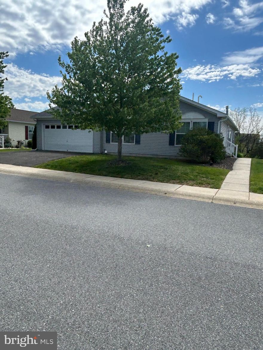 Lots of upgrades in this 3 Bed 2 Bath  Home. 2 Car garage with insulated doors and Sunburst Windows, arche beveled glass front door.  (2) skylights in Kitchen (2) in Living Room and (1) Primary Bedroom.  Sierra Stone W/raised hearth and stone mantle gas fireplace w/blower and 2 recessed lights. Laundry Room w/laundry tub. Corian counter tops in Kitchen, Island , smooth top range and built-in microwave, dishwasher and garbage disposal and walk in pantry. Sliders off Breakfast to rear side of house.  Home is impeccable and move in ready. Be the first to tour this beautiful home. In addition to ground lease there is a $50.00 Sewer and $15.75 Tax fee. Lot lease covers, Trash, snow on streets & sidewalks, grass cutting, heated pool, club House with Game room, gym, kitchen and gathering room. Lay back and relax!!
