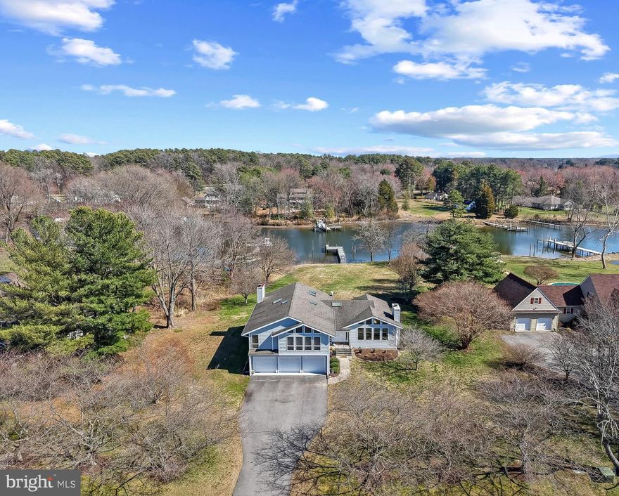 Welcome home to this waterfront property in the Eastern Shore’s premier golf course community of Prospect Bay. Set on just over an acre overlooking Little Greenwood Creek, this home offers peaceful views, spacious living areas, and direct water access. From the moment you enter, the welcoming foyer with coat closet opens to a bright living room with large windows plus a stone fireplace, and a dining area that overlooks the backyard and water, creating a light-filled space ideal for everyday living and entertaining.

The remodeled eat-in kitchen features abundant natural light, granite countertops, and direct access to the deck, where you can enjoy relaxing water views or dine outdoors. The home’s thoughtful layout continues on the lower level with an additional living area, half bathroom, laundry room, and convenient access to the spacious three-car garage. Sliding doors off the lower living area lead directly to the backyard and patio, seamlessly connecting indoor and outdoor living.

Upstairs, you’ll find four generously sized bedrooms, including a primary suite with beautiful water views, a walk-in closet, double vanity, and an electric fireplace that adds a cozy touch to the space.

Situated on a large lot, the backyard provides plenty of room for outdoor entertaining and offers the potential for a pool overlooking the water. The recently redone pier allows for easy access to Little Greenwood Creek and the Chesapeake Bay, making this an excellent opportunity for those who enjoy waterfront living and boat rides to the Narrows, Saint Michaels, Annapolis, and beyond.

Prospect Bay community offers an array of amenities, including an 18-hole golf course, a clubhouse with a members-only restaurant and bar, a marina with a launch, a pool, tennis and pickleball courts, a playground, and year-round social activities. Here, every day feels like a vacation.