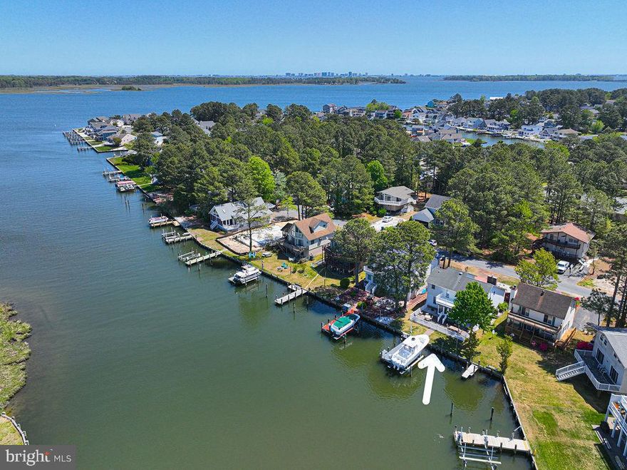 Experience the pinnacle of coastal living in this beautiful waterfront home in Ocean Pines, where breathtaking views and thoughtful, high-end renovations come together in perfect harmony. Ideally positioned on a wide lagoon overlooking a serene waterfront park, this property captures wonderful vistas out to the St. Martin River—offering both a peaceful retreat and a front-row seat to vibrant waterfront activity.  For boating enthusiasts, this location is truly exceptional. Enjoy a protected setting for your vessel on a 12,500-pound boat lift at your deeded dock, with just seconds to open water—making every day on the water effortless and inviting. Lovingly owned and meticulously renovated over the past 17 years, this home has been transformed into a stunning showcase of design and comfort. The spacious interior features five bedrooms and three beautifully updated full baths, offering plenty of room for family and guests alike.  At the heart of the home is the spectacular kitchen, completely redesigned in 2023. It boasts abundant cabinetry, gleaming granite countertops, stainless steel appliances, and a large granite island which sits 8, perfect for informal gathering and entertaining. A kitchen office with additional cabinetry adds both convenience and functionality. Complementing this space, gorgeous ceramic plank tile flooring—also installed in 2023—flows seamlessly through the kitchen, dining area, living room and hallway.  The living room features high ceilings and a stunning new fireplace added in 2024, complete with a granite hearth and elegant shiplap surround—creating a warm yet sophisticated focal point.  Throughout the home, you’ll find refined finishes including crown molding in most rooms, stylish updated fixtures, rich hardwood flooring in the upper hallways and stairs, and plush newer carpeting in the upstairs bedrooms. The home’s infrastructure has been thoughtfully upgraded as well, including a PEX manifold plumbing system for enhanced efficiency and control.  Step outside to discover equally impressive exterior features. A stone retaining wall wraps the property, framing low-maintenance landscaping and enhancing curb appeal.  Enjoy tranquil river views from the three-season porch, or entertain with ease in the fenced patio area—perfect for grilling and gatherings. The perpendicular pier and boat lift installed in 2021 complete this exceptional waterfront package.  Whether you’re watching boats glide by, casting a line, spotting local wildlife, or simply unwinding as the sky ignites with sunset hues, this home offers an unparalleled waterfront lifestyle. From here, the St. Martin River leads to the back bays of Ocean City, the inlet, and the natural beauty of Assateague Island—opening up endless opportunities for exploration.  Located within one of the Eastern Shore’s most sought-after communities, Ocean Pines offers outstanding amenities including 5 pools (one is an indoor pool), a championship golf course, racquet sports facilities, a marina and yacht club with dining, a private beach club, and scenic walking trails—all with low HOA fees.  This one-of-a-kind property is a true gem—artfully renovated, impeccably maintained, and perfectly positioned. Don’t miss your chance to own this wonderful waterfront retreat. Schedule your private showing today.