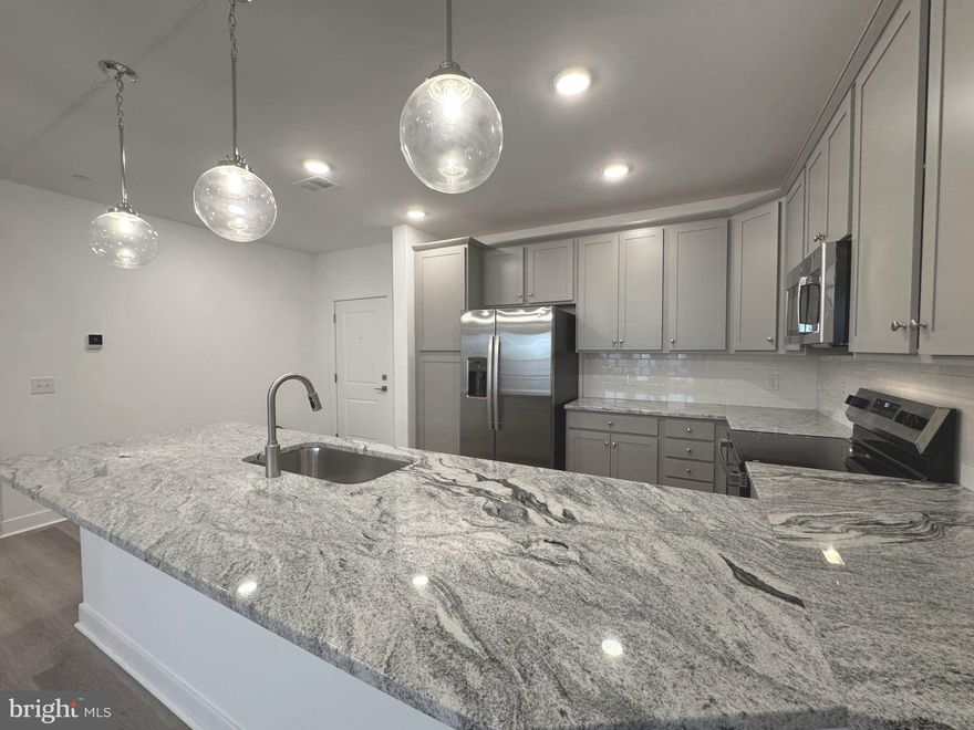 Welcome to 21731 Dovekie Terrace #304, where modern luxury meets effortless living. This brand-new elevator condo offers true single-level living with 2 spacious bedrooms, 2 full baths, and a private home office — perfect for hybrid work or creative space. With over 1,300 sq ft of sleek design, enjoy 9-foot ceilings, luxury vinyl plank floors, a private balcony for morning coffee, and a meticulous, open-concept kitchen with stainless steel appliances and quartz countertops.

Located in Waxpool Crossing, this light-filled unit brings together comfort, community, and convenience. Step outside to enjoy amenities like a community grill and outdoor pavilion , and lots of areas to enjoy your morning run. Garage parking, elevator access, and fellow young professionals make everyday living effortless.

You’re just minutes from the Silver Line Metro, One Loudoun, and some of the best shopping, dining, and nightlife in Northern Virginia. Whether you’re working downtown or playing locally, this home offers the perfect balance of vibrant lifestyle and modern sophistication — all under a full builder warranty for peace of mind.

Now available and ready for move-in — come experience Ashburn living at its best. SCHEDULE YOUR TOUR TODAY!