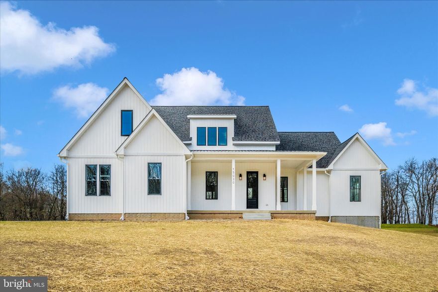 Custom built craftsman home nestled on 1.7 acres in rural Frederick County.  Experience the perfect blend of rustic surroundings and modern details in this beautiful, newly constructed contemporary home.  Lots of curb appeal with crisp white batten board siding and black framed windows.  The first floor is open concept with 10-foot ceilings, throughout.  Gourmet kitchen with functional, working pantry fit with custom cabinetry, shelving, beverage fridge and countertops.  Plenty of island space for entertaining.  Spacious living room with custom gas fireplace and double oversized doors leading outside to a covered back porch.  Hard wood floors throughout.  First floor primary bedroom, ensuite, laundry and powder room on one side of the home, while two additional bedrooms and shared bath preside on the opposite side.  Large additional bedroom room located on the second floor with its own private, full bathroom.  Basement level is walkout with endless opportunities: add additional living space, home gym or office.  Cement framed room in basement for a potential wine cellar or saferoom.  Protected farmland surrounds this home ensuring privacy for years to come.  Back yard is a blank canvas, ready for you to create your own private sanctuary with a garden, patios, or pool.