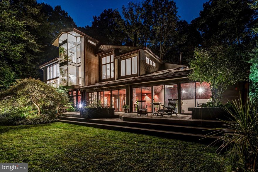 Welcome to 7313 Brookstone Court, an exquisite California style cedar home tucked away in the wonderful Mazza neighborhood of Potomac, Maryland. A private driveway graciously invites you to the front of the residence, showcasing meticulously crafted gardens and expert landscaping. Step through the front door and prepare to be mesmerized by treetop vistas, seamlessly visible through the floor-to-ceiling windows enveloping the living room and dining area at the rear of the home. The kitchen has undergone a comprehensive renovation, beautifully redesigned by Gallin Beeler Design Studio. This space truly dazzles with its vaulted ceilings, custom wood cabinetry, stone tile flooring, and top-of-the-line stainless steel appliances. Built-in display shelving graces the sitting area and access to the mudroom and four-car garage, complete with an EV charger, can be found beyond the door. Step outside onto the deck through the sliding glass doors, wonderfully blending indoor and outdoor living. The captivating living room is an absolute showstopper, boasting a wood-paneled vaulted ceiling that adds a touch of rustic elegance. Oversized windows frame picturesque views of the backyard, flooding the room with natural light. Custom lighting accents the space, while a cozy gas fireplace invites relaxation and gatherings. This expansive room effortlessly flows into the dining area, creating a harmonious space for entertaining and fabulous wall space for art display. With ample room to accommodate larger gatherings, the dining area offers glass doors to further enjoy the breathtaking backyard views. An elegantly designed powder room and a hall closet round out this main level. Step down to the charming family room which is crafted with custom built-in cabinetry and shelving, providing the perfect showcase for your cherished display items. The tile surround wood-burning fireplace is a focal point, with nearby wet bar and storage closet to the side of the room. Continue through the glass doors into the attached sunroom with flagstone flooring, and impressive natural light from its floor-to-ceiling windows. Tucked around the corner, an inviting office space awaits, providing an ideal ‘at-home’ workspace. The primary suite stands out as a true retreat, featuring vaulted ceilings, skylights, and panoramic windows along the rear of the house, offering stunning views of the surrounding wooded area. The generously proportioned bathroom is wrapped with spa-like tilework and includes a spacious frameless two head walk-in shower, bathtub, dual vanities, and is located adjacent to both walk-in closets. As you proceed down the hallway, discover three additional bedrooms. Two bedrooms offer views of the backyard and share a stylishly appointed 'Jack and Jill' bathroom, while the third bedroom offers its own en-suite bathroom. Adding to the functionality of the upper level, a conveniently placed laundry room in the hallway simplifies your daily routine. The lower level of this home is a rare discovery, featuring an indoor black bottom saltwater pool. Measuring thirty feet in length and approximately ten feet in depth, this exquisite pool is surrounded by handsome wood-paneled walls, complimented by skylights and windows that frame the backyard, creating an unparalleled sanctuary. Adjacent to the pool, a comfortable sitting area awaits and a bonus enclosed fitness room. Completing this level is a lower-level bathroom, providing a space to refresh after enjoying the pool. Enhanced by a network of enchanting garden paths, this residence epitomizes the essence of a peaceful sanctuary. Situated within the Whitman School District, convenience is at your doorstep, with easy access to Clara Barton Parkway, I-495, and the Potomac Village just minutes away. With its unique features and central location, this exceptional home will not last long. Do not miss this fabulous opportunity to make this home yours.