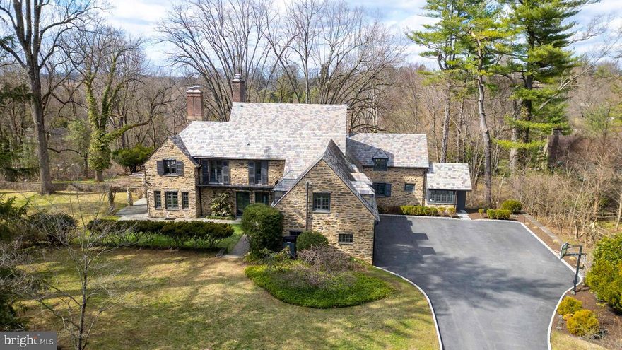 The distinguished residence at 99 East Bells Mill Road in North Chestnut Hill sits on nearly two acres of beautifully landscaped land, offering cool breezes, exceptional privacy, and sweeping views in every direction. Designed in 1925 by the renowned firm Willing, Sims & Talbott, the home carries a relaxed, modern sensibility — one that honors its English country roots while embracing an effortless connection to the natural world.

Ten recently replaced, energy-efficient doors open from the first floor to the outside, blurring the line between interior living and the stunning landscape beyond. Enter through a gracious front passageway that flows to the back garden or into the home’s welcoming entry hall. A gallery leads past the generous dining room — where three French doors open onto an entertainment-sized bluestone terrace — and into the captivating living room, lined with French doors and windows on three sides that flood the space with light and views. Custom millwork, built-in bookcases, and an elegant powder room finished in Venetian plaster complete the refined first floor.

The showstopper is the kitchen and back-of-house suite — a spectacular reimagining completed less than two years ago by one of the region’s top residential architects in collaboration with a celebrated kitchen designer. As uplifting as it is functional, the space includes a beautifully appointed back entry that serves as a mudroom elevated to an art form.

Upstairs, five bedrooms and four updated full bathrooms are arranged across three separate wings, offering exceptional privacy. A recently renovated guest wing adds flexible living space, and the expansive third floor is ideal as a sixth bedroom, studio, or gym.

Every upgrade has been executed with architectural sensitivity — new windows, updated HVAC, revitalized gardens, enhanced hardscaping, and upgraded electrical and lighting systems reflect the masterful stewardship of this remarkable property.
Walk to Chestnut Hill’s shops and restaurants, jog into the Wissahickon Valley, and explore the Morris Arboretum in every season. Regional rail is less than a mile away, with easy access to major highways. This one is special — don’t wait to see it.​​​​​​​​​​​​​​​​