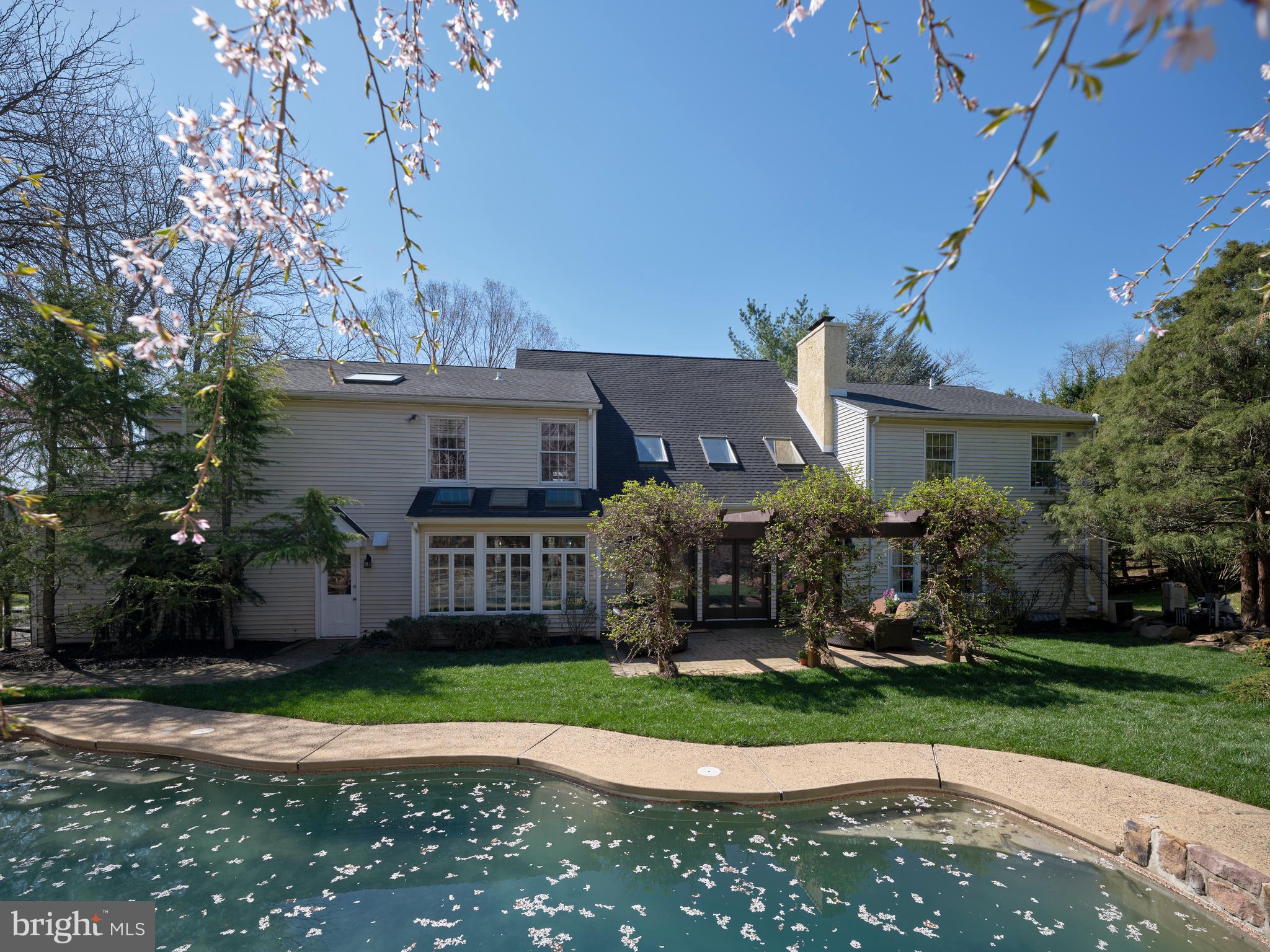 Within one of the most prestigious neighborhoods, Plumstead Township, sits Nottingham Woods. This
expansive home offers a grand façade that reflects the sophistication of the home’s interior. The newly paved driveway and red brick walkway, delivers you to the entrance of this exciting residence.
You are greeted with an open foyer, approximately 20 feet in height. The formal dining room, with contemporary chandelier, is spacious enough for large family dinner holiday gatherings.
To the left of this foyer is the paneled library or office. The built-in cabinetry is perfect for books, files or collectibles. A fireplace completes this room and adds to the warmth both physically and aesthetically.
The large primary bedroom is flooded with natural light and beautiful hardwood floors with a gleaming patina. The fireplace adds to the excitement of this private spa. The primary en-suite offers a large shower, jetted tub, dual sinks, electric towel warmer and beautiful tile flooring. A generous walk-in closet completes desirable suite.
There are total of 5 bedrooms and 4 full baths and 2 half baths,
The living space on the first floor is composed of a contemporary living room with vaulted ceiling, a wall of sliding glass doors, skylights and an exceptional fireplace. This room is ideal for entertaining on all levels.
The kitchen is an open concept with a large breakfast bar, an independent breakfast area that is nestled into a unique area composed of a wall of windows and skylights above. The high-end chef’s kitchen contains stainless-steel appliances that would excite all cooks.
The finished basement is carpeted and can be anything from a home gym, theater or “teen” gathering spot. Your limits are controlled by your imagination. The impressive wine room is an amenity rarely found in homes today.
The exterior of the home is serene and creates a sense and creates a sense of nirvana with the pergola, natural stone pool and spa and mature flooring trees. A small cabana with a half bath and bar, immediately becomes the summer “watering hole.”
Nottingham Woods is a home that will elevate your lifestyles, the summer months and the wonderful promise reflective of Bucks County.