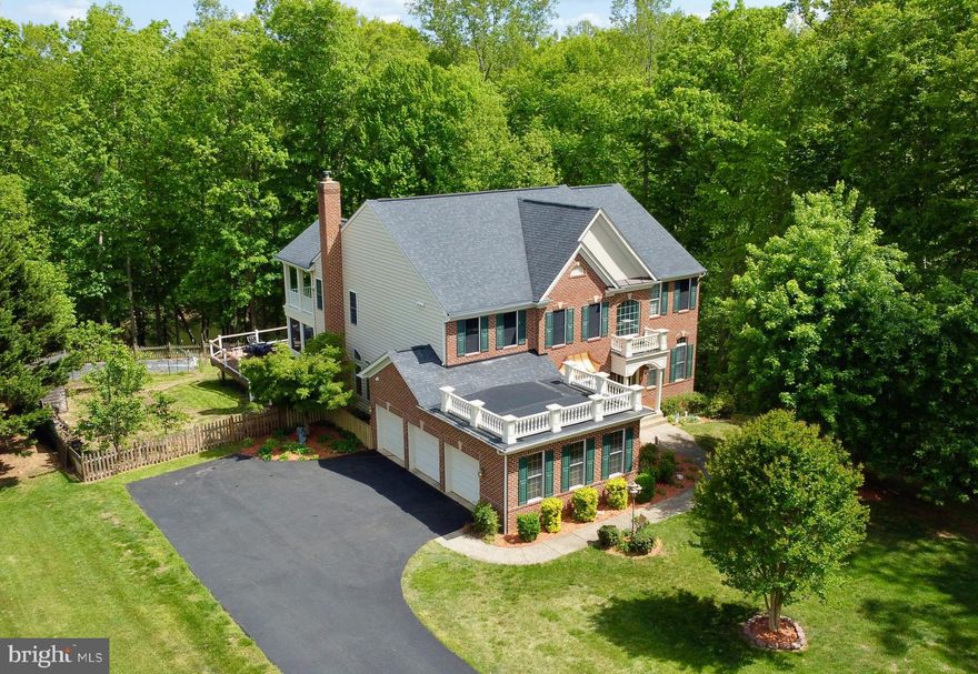 COMING SOON | A Waterfront Estate of Distinction. Gracefully sited on three pristine acres at the end of a quiet cul-de-sac, this extraordinary custom waterfront residence offers a rare blend of privacy, scale, and sweeping views of Smith Lake. Encompassing over 5,600 square feet across three impeccably finished levels, this five-bedroom, four-and-a-half-bath estate is designed to impress at every turn.  From the moment you arrive, the home’s stately presence and three-car garage set the tone for what lies within. Inside, rich hardwood flooring flows throughout the main level, staircase, and upper hall, complemented by soaring 10-foot ceilings and exquisite custom millwork that elevate each space with timeless elegance.  Designed for both grand entertaining and intimate living, the main level showcases expansive gathering spaces, including formal living and dining rooms, and a private study adorned with French doors. At the heart of the home, a gourmet kitchen features a generous center island, gleaming granite countertops, custom cherry cabinetry, and stainless steel appliances—all seamlessly opening to a warm and inviting family room anchored by a striking stone fireplace. A vaulted sunroom bathed in natural light offers the perfect setting to relax and take in tranquil lake views.  Upstairs, a luxurious owner’s retreat serves as a true sanctuary, complete with a tray ceiling, private covered porch overlooking the water, multiple walk-in closets, and a spa-inspired bath with a soaking tub and dual vanities. Three additional bedrooms and well-appointed baths provide comfort and flexibility for family and guests alike.  The fully finished walk out terrace level is an entertainer’s dream, boasting a granite wet bar and expansive recreation spaces ideal for movie nights, gaming, or hosting gatherings. A substantial storage area ensures effortless organization.  Outdoor living is equally captivating, with a large Trex deck, screened porch, and panoramic views to enjoy the serene beauty of Smith Lake year-round.  Recent updates include HVAC systems (2025/2022), water heater (2020), and roof (2017), offering peace of mind for years to come.  Ideally located just minutes from Route 95, Quantico, and the vibrant shopping and dining along Garrisonville Road, this exceptional estate presents a rare opportunity to experience refined waterfront living at its finest.  NO HOA!